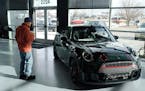 FILE - A man looks at a 2024 Cooper S John Cooper Works convertible at a Mini dealership on Nov. 30, 2023, in Loveland, Colo. Automobile prices, which