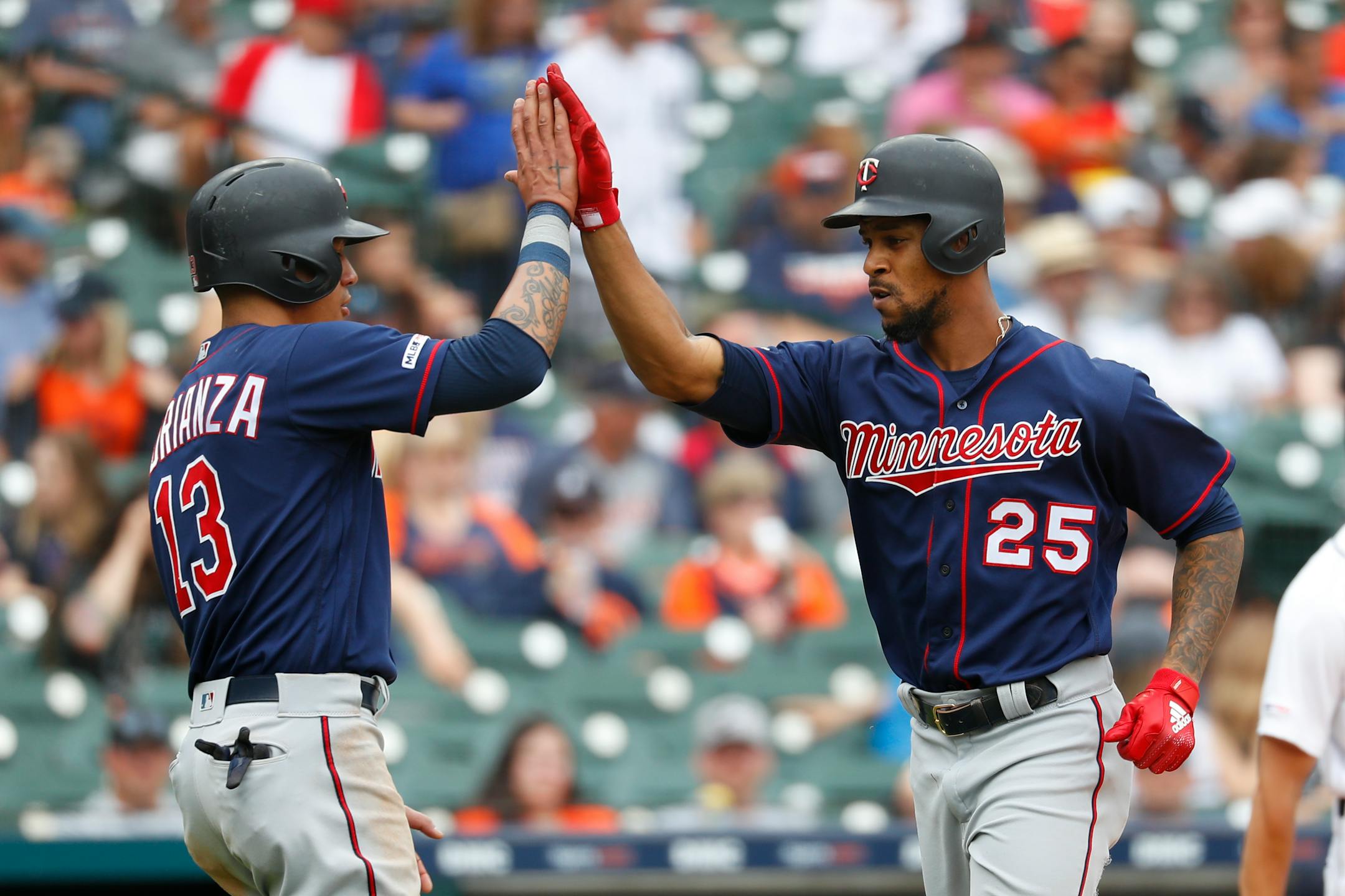 Minnesota Twins' Byron Buxton (25) celebrates his two-run home run with Ehire Adrianza (13) in the sixth inning of a baseball game against the Detroit Tigers in Detroit, Sunday, June 9, 2019. (AP Photo/Paul Sancya)
