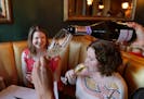 Shannon Maloney pours the champagne for Melissa Norton, left, as Katelynne Snyder has a taste for an after Dinner treat at the Stem Wine Bar in North 