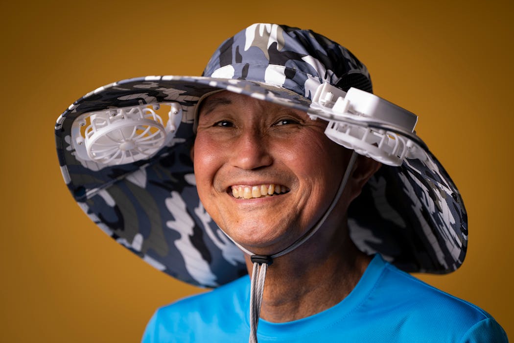 Seigo Masubuchi in a sun hat with two solar-powered fans.