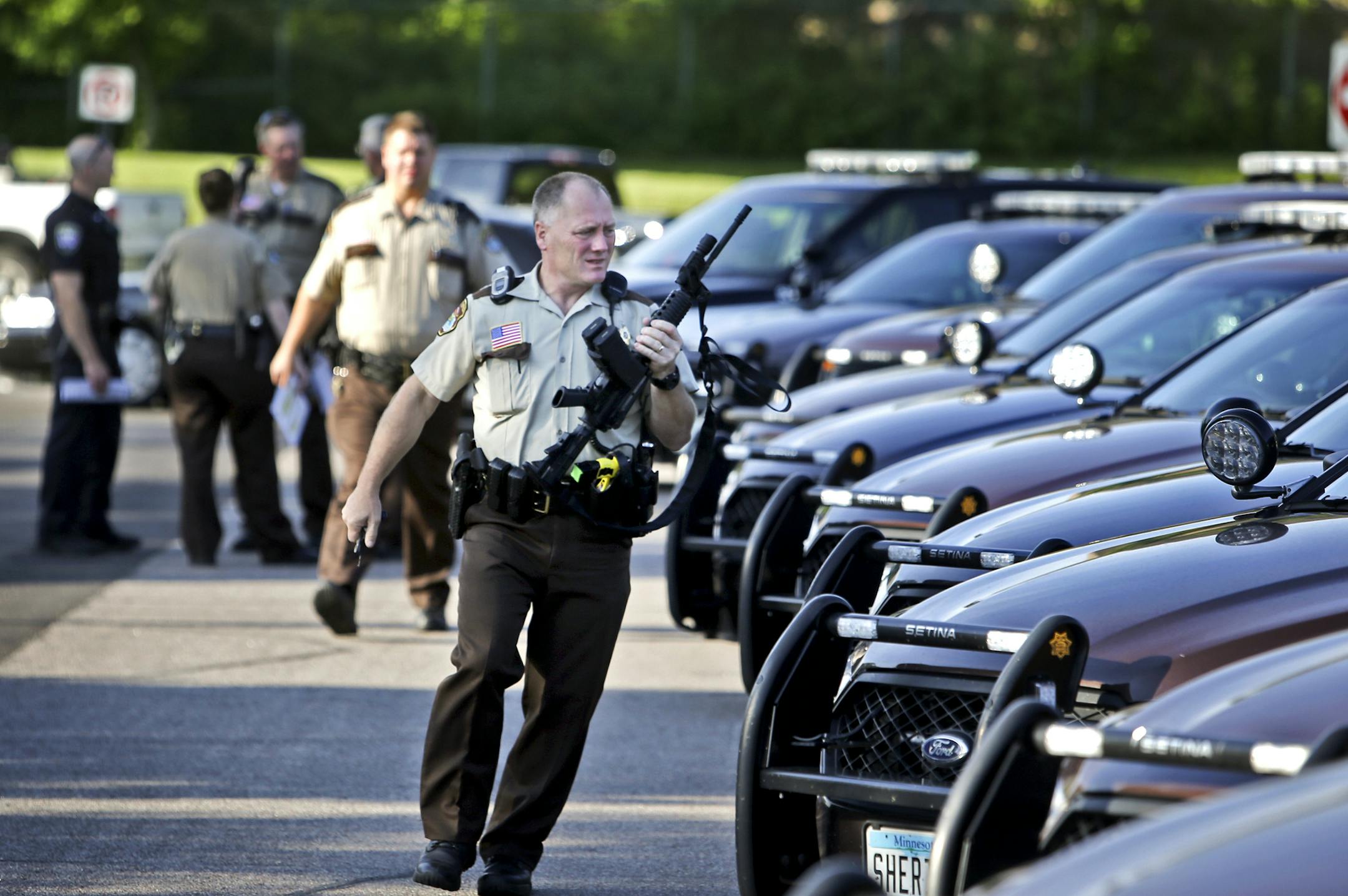 An officer heads to his car during an agency-wide sweep of offenders with drug-related charges who have not turned themselves in Tuesday at the Hennepin County Sheriff's office in Brooklyn Park.