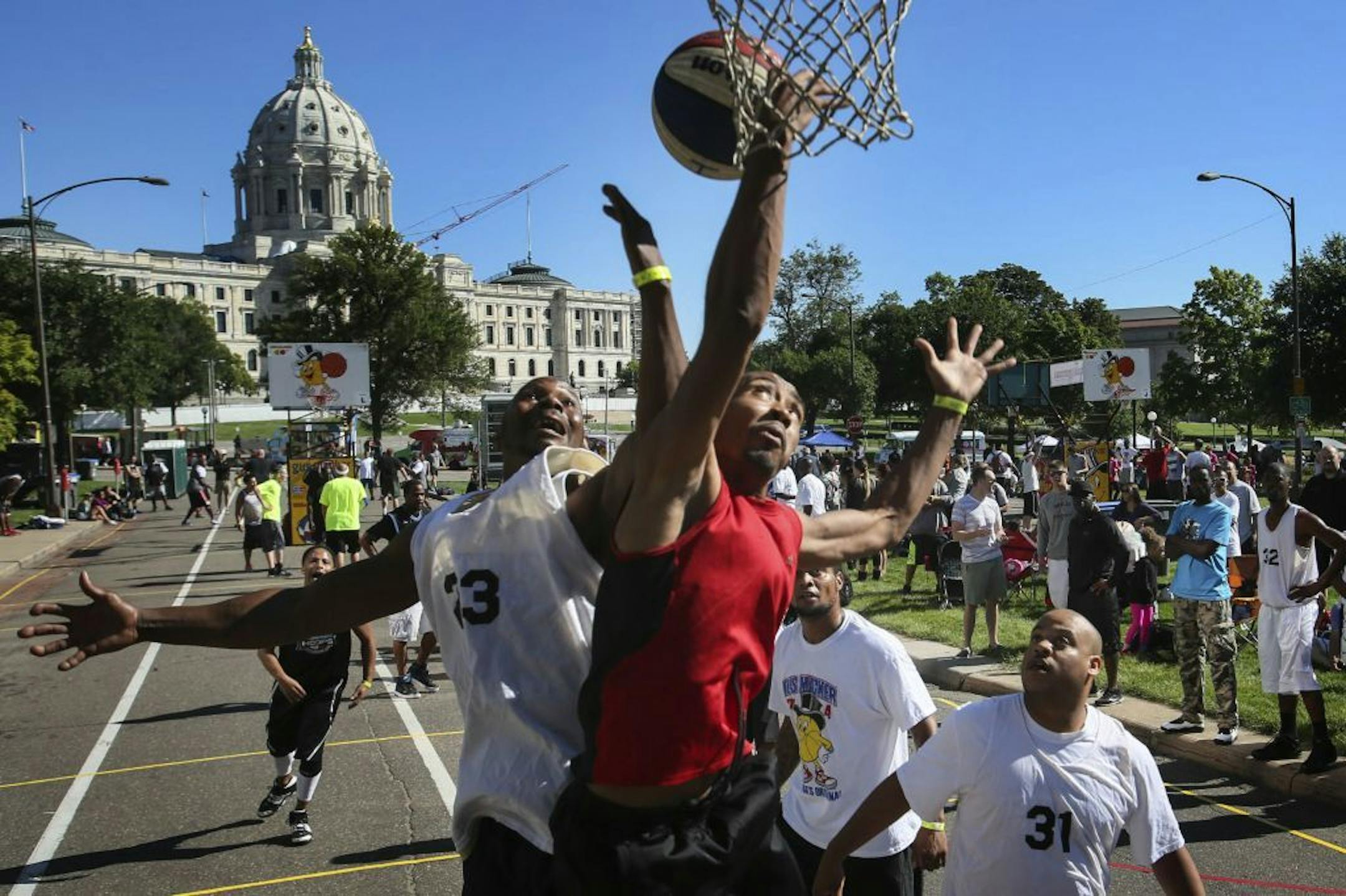 Members of Mobbs Up in light and Teamwork in dark battled for a rebound during the Gus Macker 3-on-3 basketball tournament near the Minnesota State Capitol Saturday, Sept. 6, 2014, in St. Paul MN. Mobbs Up won 15-9 to advance.