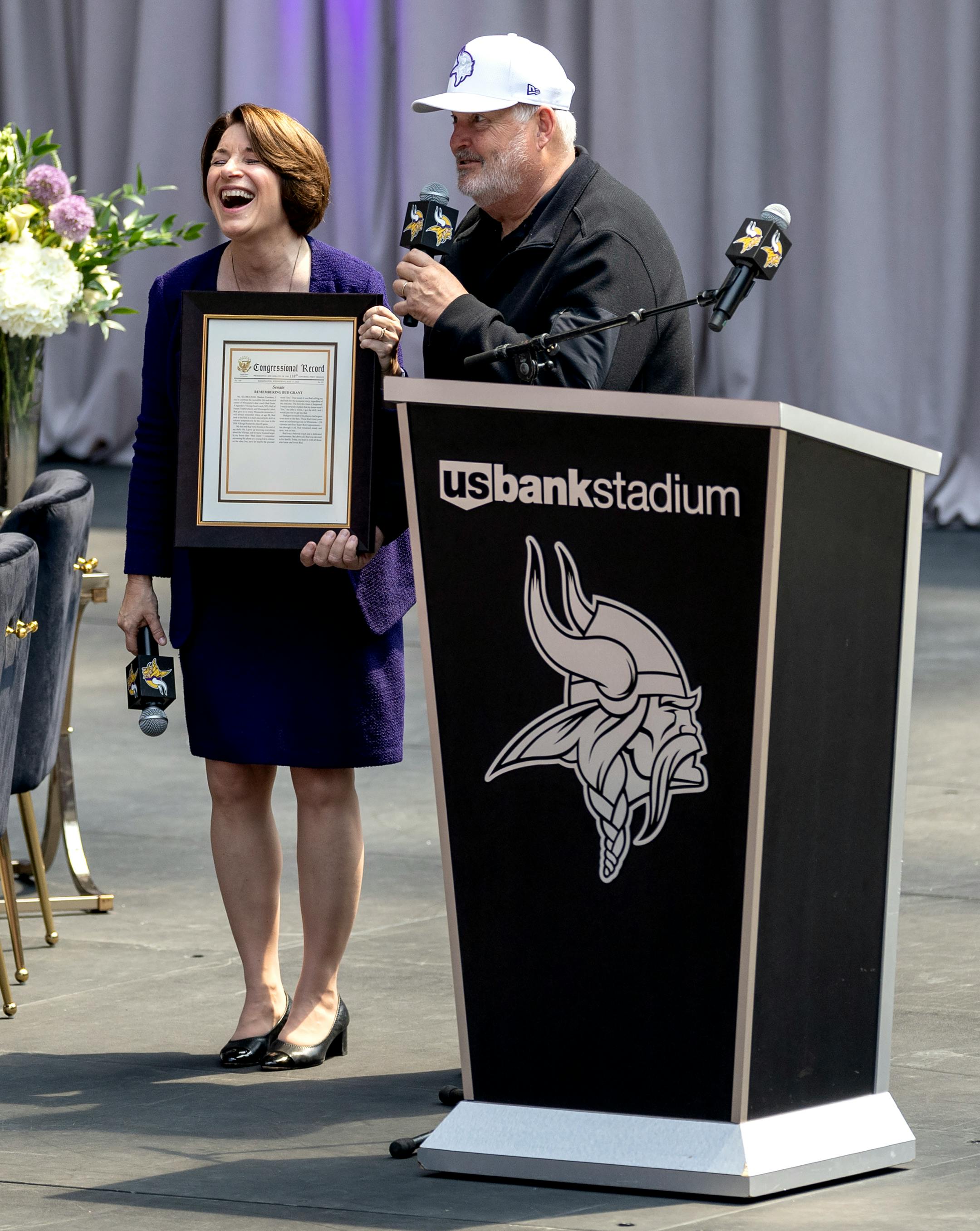 Senator Amy Klobuchar presented Mike Grant with a document honoring his father during a public celebration of for Minnesota Vikings coach Bud Grant.