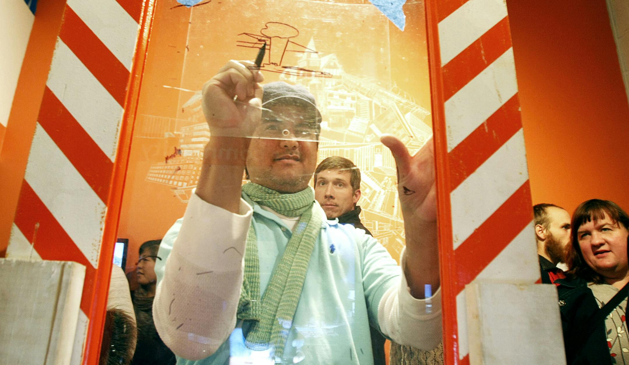 Mike Hoyt traces a building on the mobile tracing unit during the Creative CityMaking Community Celebration and Forum at Intermedia Arts in Minneapolis, Minn., on Friday, November 22. The mobile tracing unit was used during a public engagement campaign to involve community members in observing and documenting historic architecture by asking them to trace the outline of buildings on transparencies mounted to a frame on the street. ] Chris Kelleher, Special to the Star Tribune, 11/2/2013, Minneapo