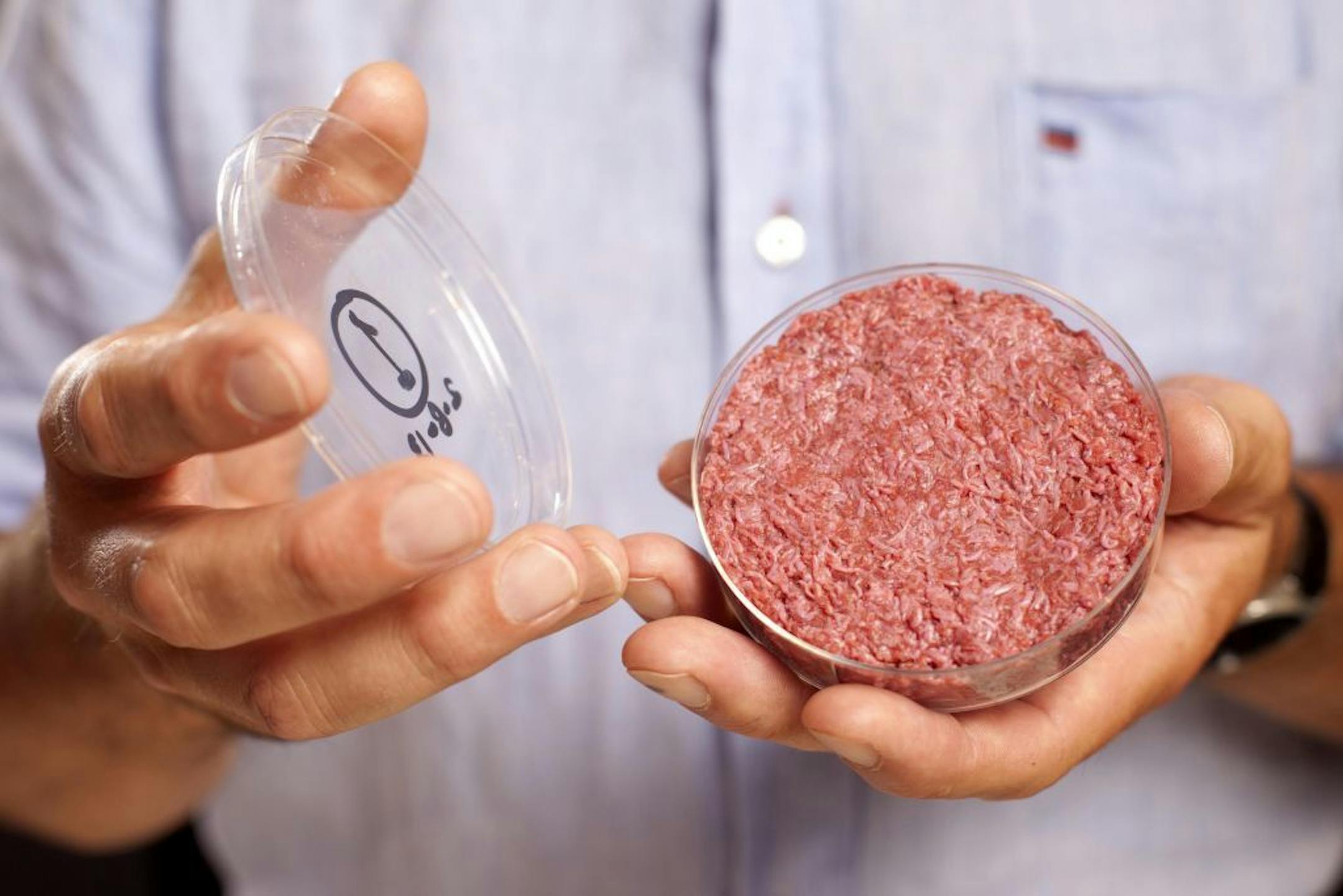 A new Cultured Beef Burger made from cultured beef grown in a laboratory from stem cells of cattle, is held by the man who developed the burger, Professor Mark Post of Netherland's Maastricht University, during a the world's first public tasting event for the food product in London, Monday Aug. 5, 2013. The Cultured Beef could help solve the coming food crisis and combat climate change according to the producers of the burger which cost some 250,000 euros (US dlrs 332,000) to produce. (AP Photo