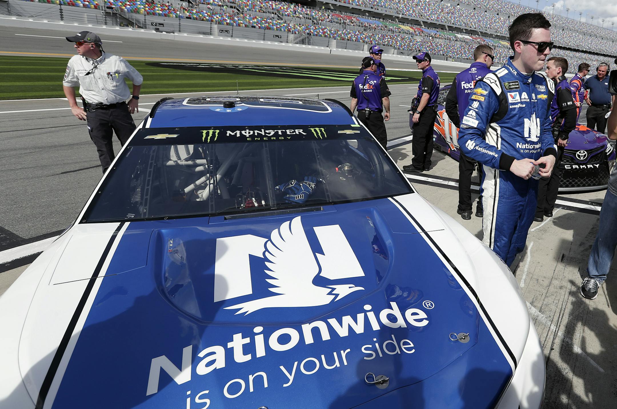 Alex Bowman, right, stands by his car on pit road after he won the pole position during qualifying for the NASCAR Daytona 500 auto race at Daytona International Speedway, Sunday, Feb. 11, 2018, in Daytona Beach, Fla. (AP Photo/John Raoux)
