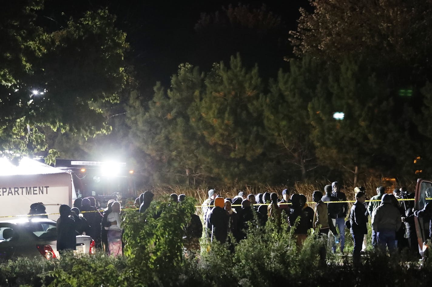 Members of the Somali community gather at the scene.