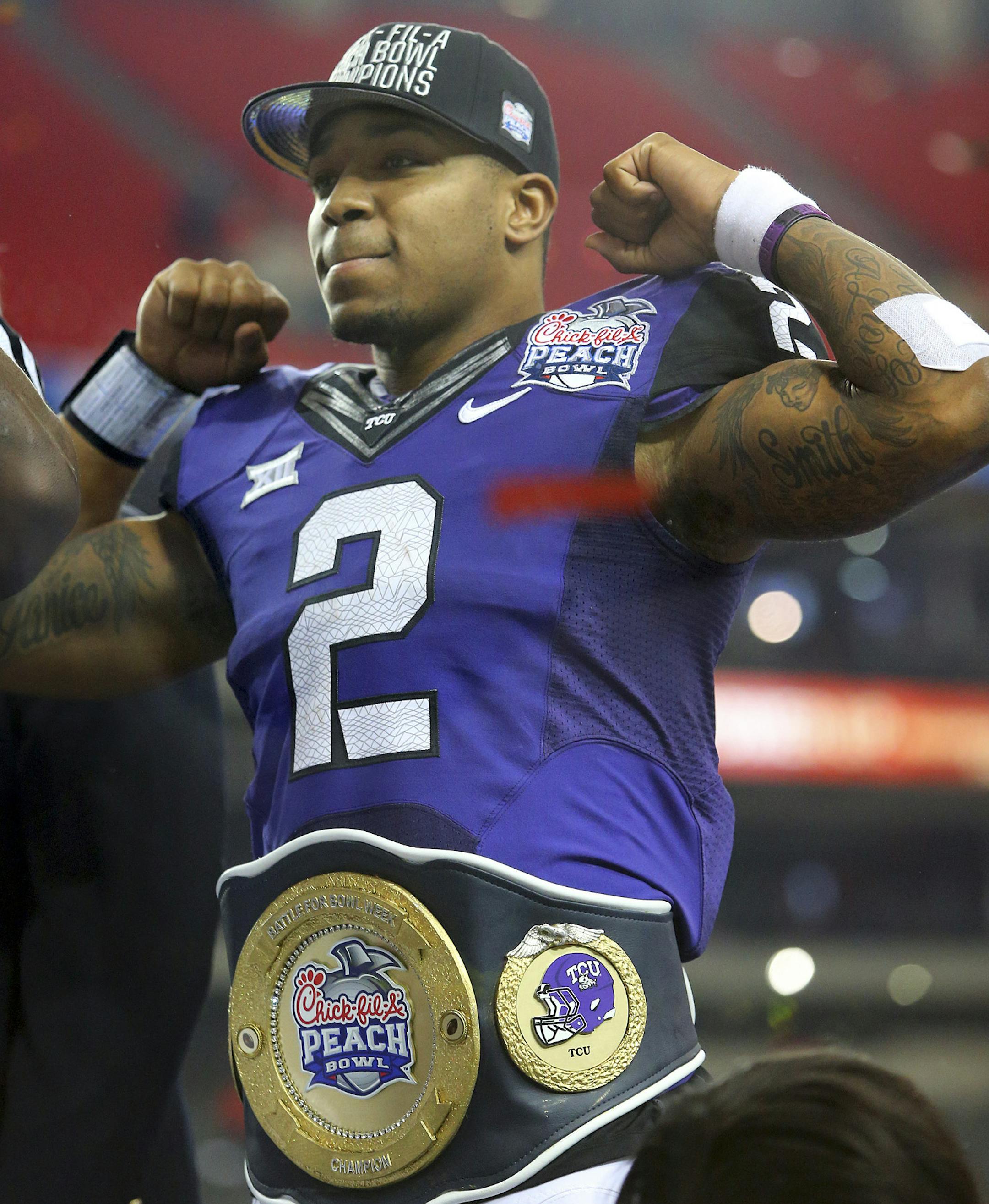 Offensive player of the game TCU quarterback Trevone Boykin flexes on stage after beating Mississippi 42-3 to win the Peach Bowl NCAA college football game on Wednesday, Dec. 31, 2014, in Atlanta. (AP Photo/Atlanta Journal-Constitution, Curtis Compton) ORG XMIT: MIN2015010220133406