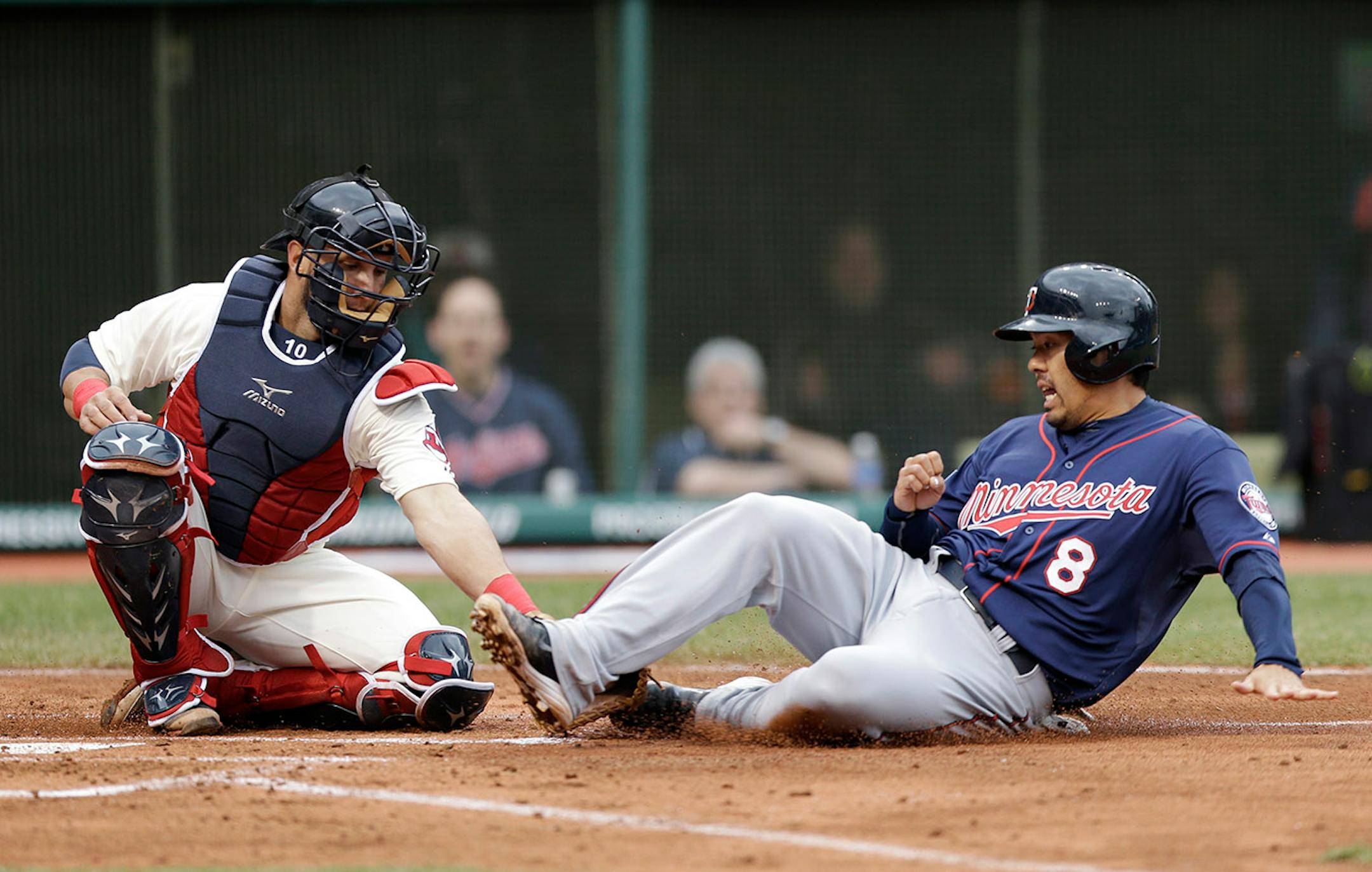 Minnesota Twins' Kurt Suzuki, right, slides into home plate as Cleveland Indians' Yan Gomes tags him out in the second inning of a baseball game, Friday, April 4, 2014, in Cleveland. Suzuki tried to score on a single by Brian Dozier. (AP Photo/Tony Dejak)