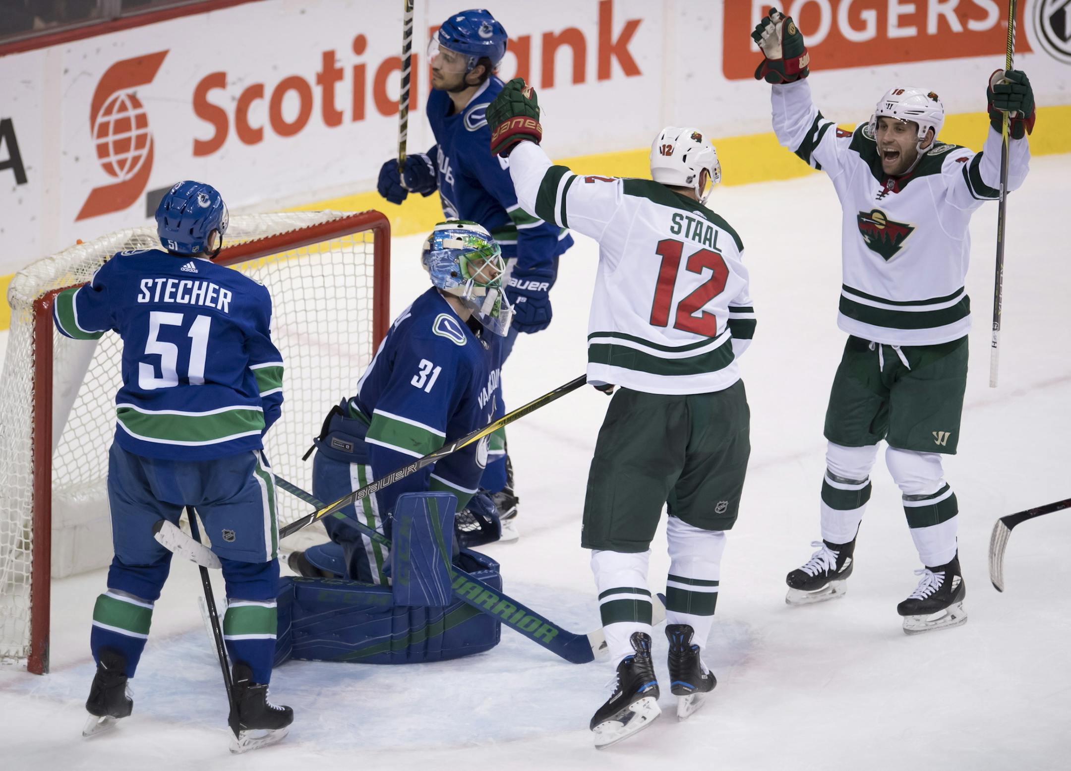 Minnesota Wild center Eric Staal (12) celebrates his goal past Vancouver Canucks goaltender Anders Nilsson (31) as Wild left wing Jason Zucker (16) and Canucks defensemen Troy Stecher (51) and Michael Del Zotto (4) react during the second period of an NHL hockey game Friday, March 9, 2018, in Vancouver, British Columbia. (Jonathan Hayward/The Canadian Press via AP)