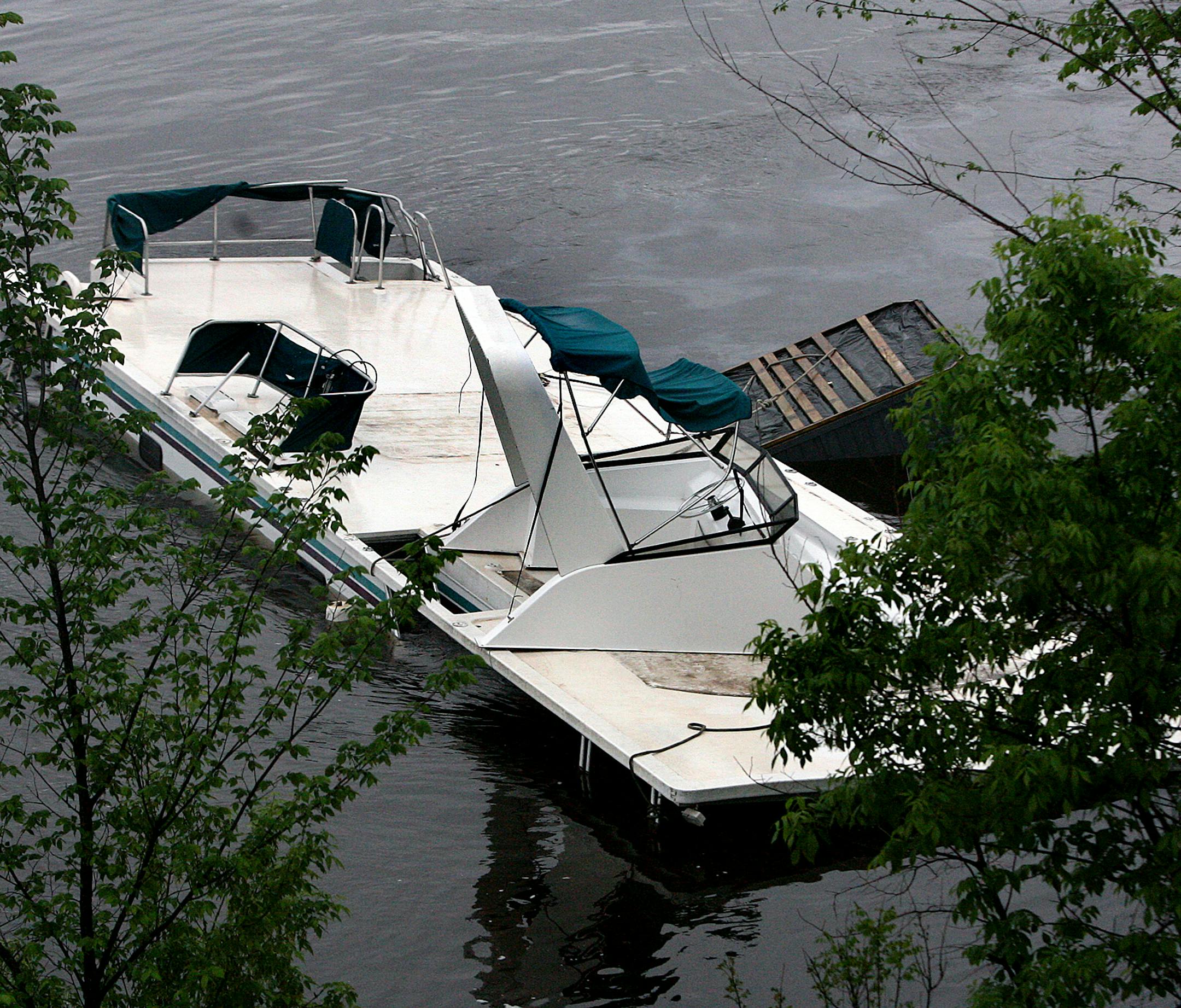 A houseboat is seen mostly submerged on the main channel of the Mississippi River, Monday, May 27, 2013 when 11 people were rescued after the boat came under distress below lock and dam 7 at Dresbach. Minn. (AP Photo/La Crosse Tribune, Peter Thomson)