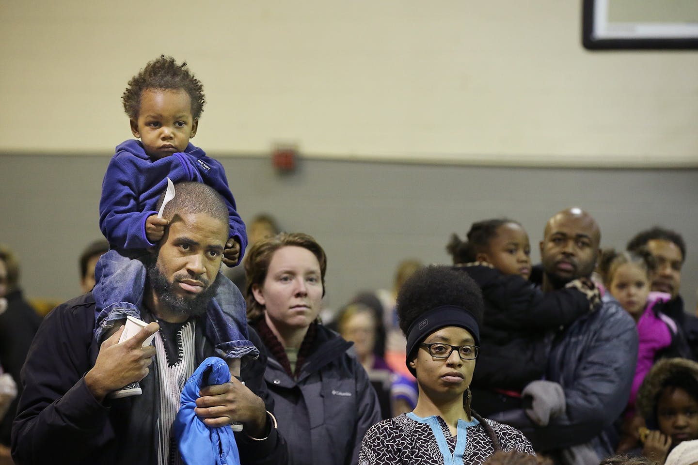 Ajax Hall, 2, got a better view of the program on his father, Elisha Hall, as they watched the entertainment at the annual Powderhorn Park Martin Luther King, Jr. Celebration, Monday, January 18, 2016.