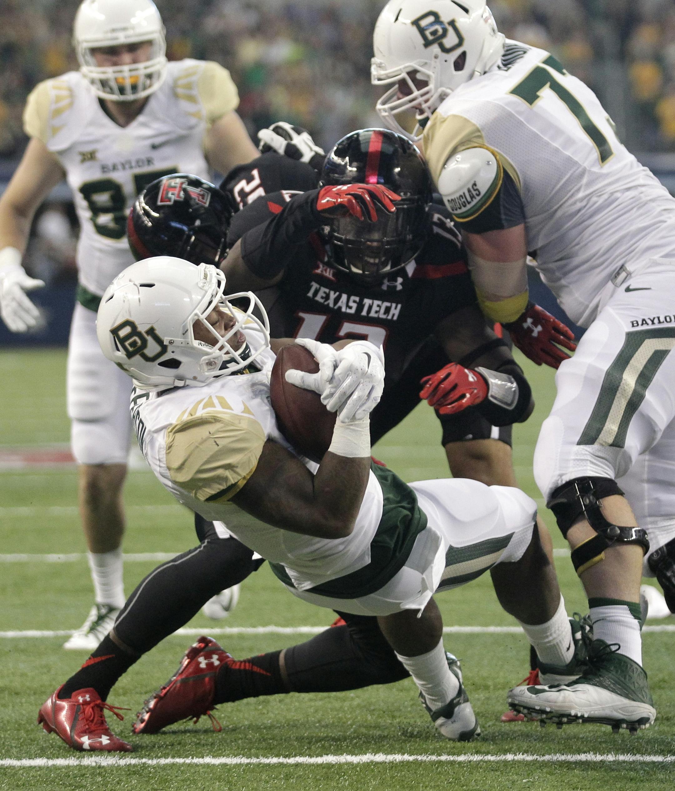Baylor running back Johnny Jefferson scores a touchdown against Texas Tech linebacker Sam Eguavoen (13) with the assistance of offensive lineman Patrick Lawrence (77) in the first half of an NCAA college football game, Saturday, Nov. 29, 2014, in Arlington, Texas. (AP Photo/Tim Sharp)