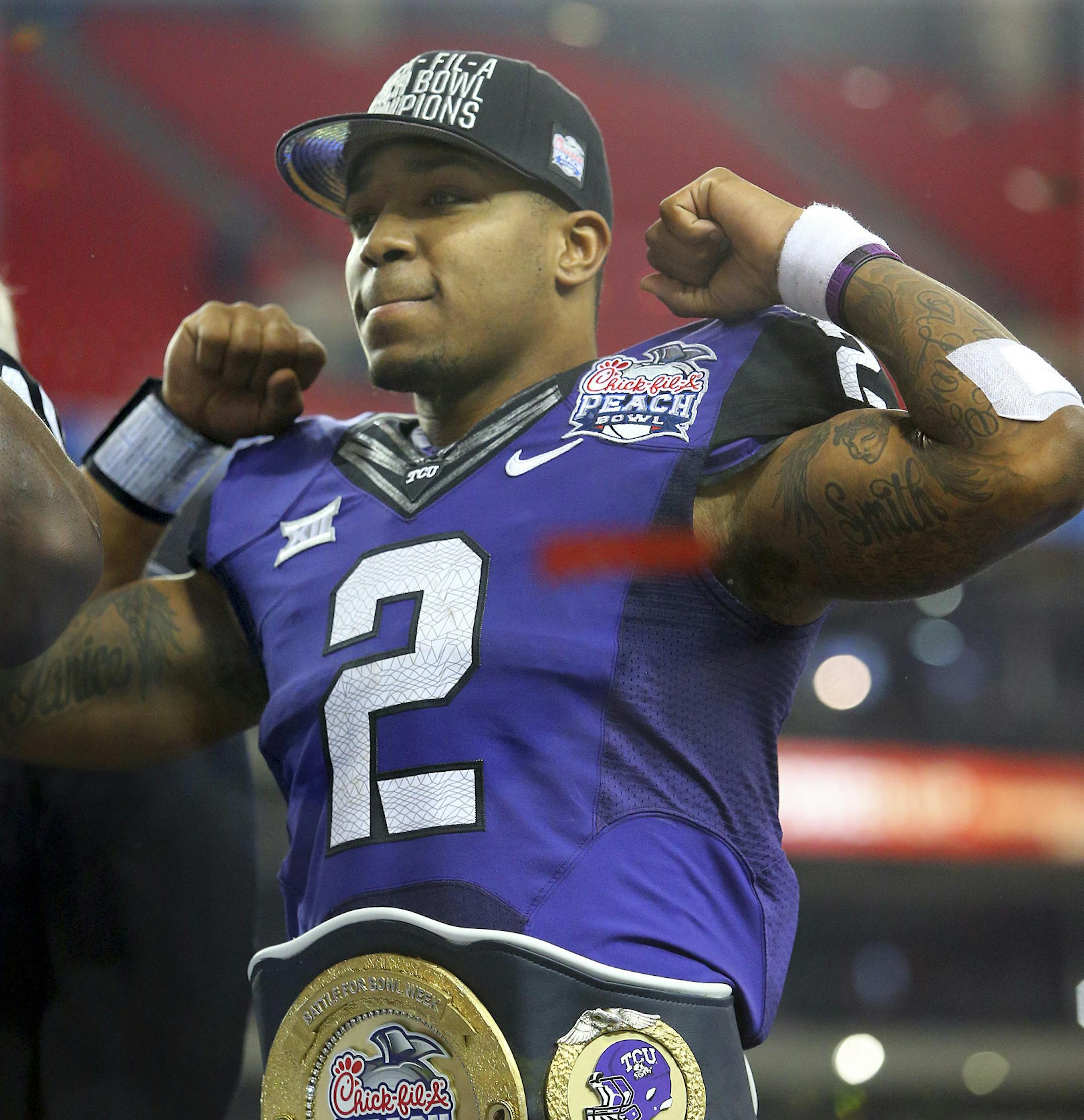 Offensive player of the game TCU quarterback Trevone Boykin flexes on stage after beating Mississippi 42-3 to win the Peach Bowl NCAA college football game on Wednesday, Dec. 31, 2014, in Atlanta. (AP Photo/Atlanta Journal-Constitution, Curtis Compton) ORG XMIT: MIN2015010220133406