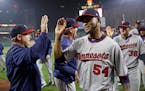 Minnesota Twins starting pitcher Ervin Santana (54) celebrates with coaches and teammates after closing out a baseball game against the Baltimore Orio