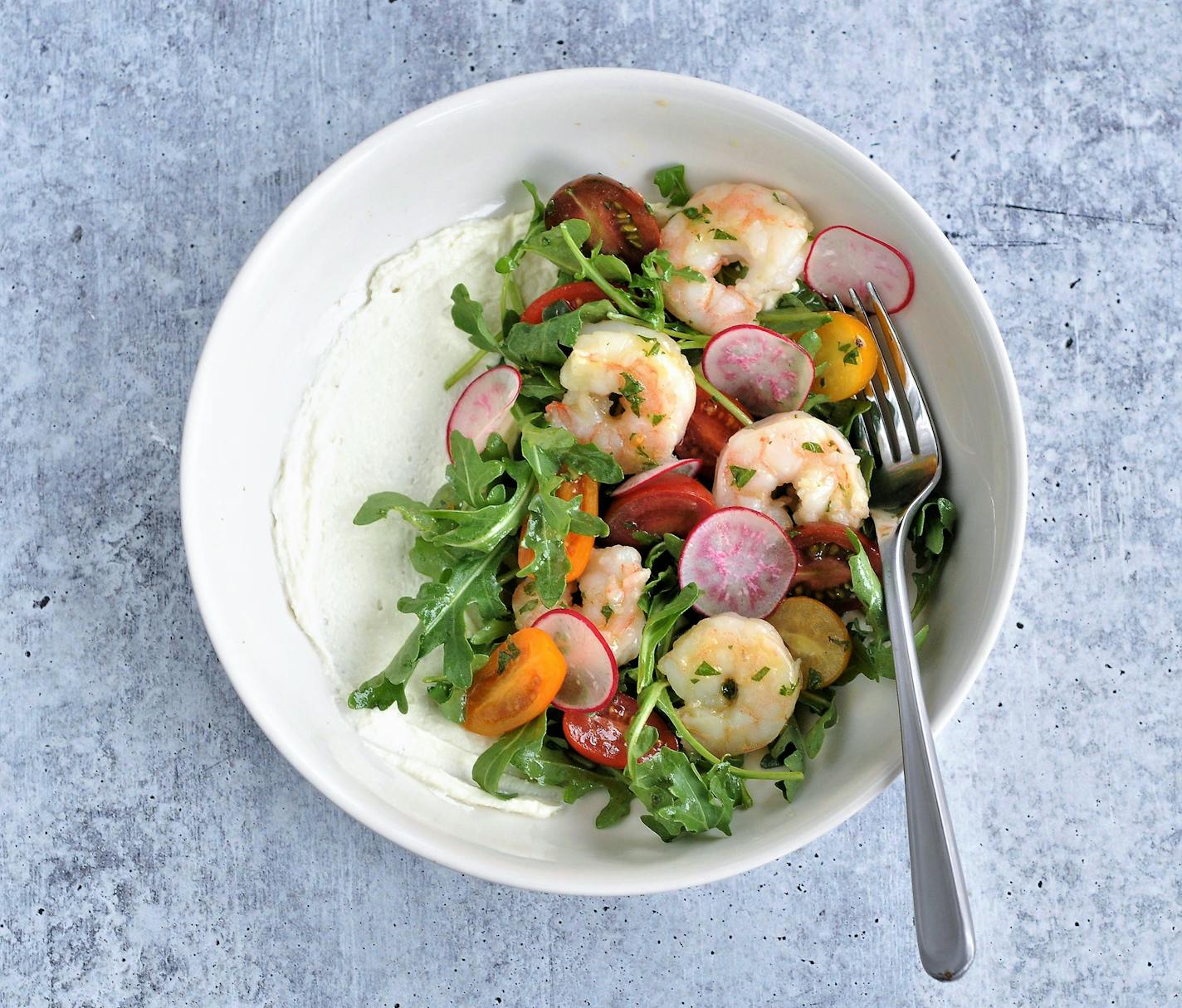 A snappy shrimp salad sits atop a swipe of creamy feta for a springtime salad. Shrimp and Arugula Salad with Mint Vinaigrette and Whipped Feta. Credit: Meredith Deeds