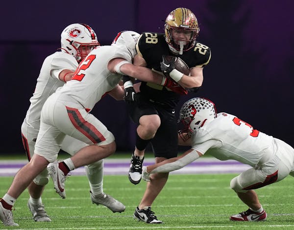 Connor Cade (28) of Lakeville South is tackled by the Centennial defense in Minneapolis, Minn., on Thursday, Nov. 16, 2023. Class 6A football state se