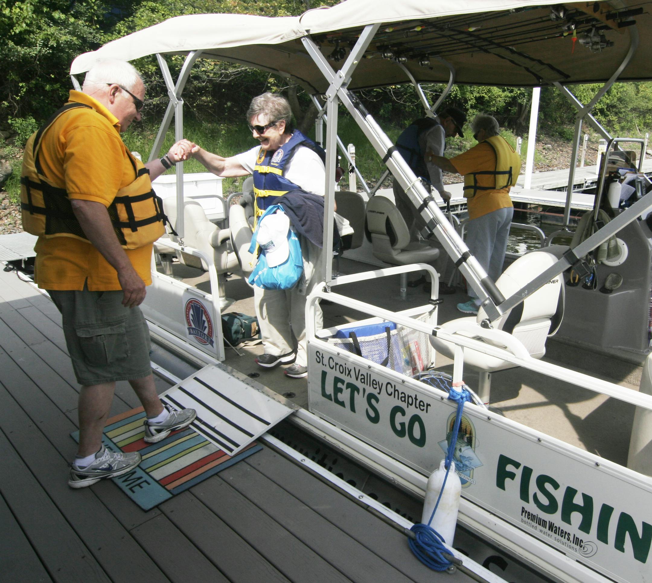 Wayne Beyer, 69, of Bayport helps Barb Welp, 77, off the Let's Go Fishing pontoon boat at Bayport Marina after a two-hour fishing trip on the St. Croix River. The local chapter of the nonprofit group bought the $40,000 boat with donations and sponsors, and takes seniors, veterans and youths on the water for free.