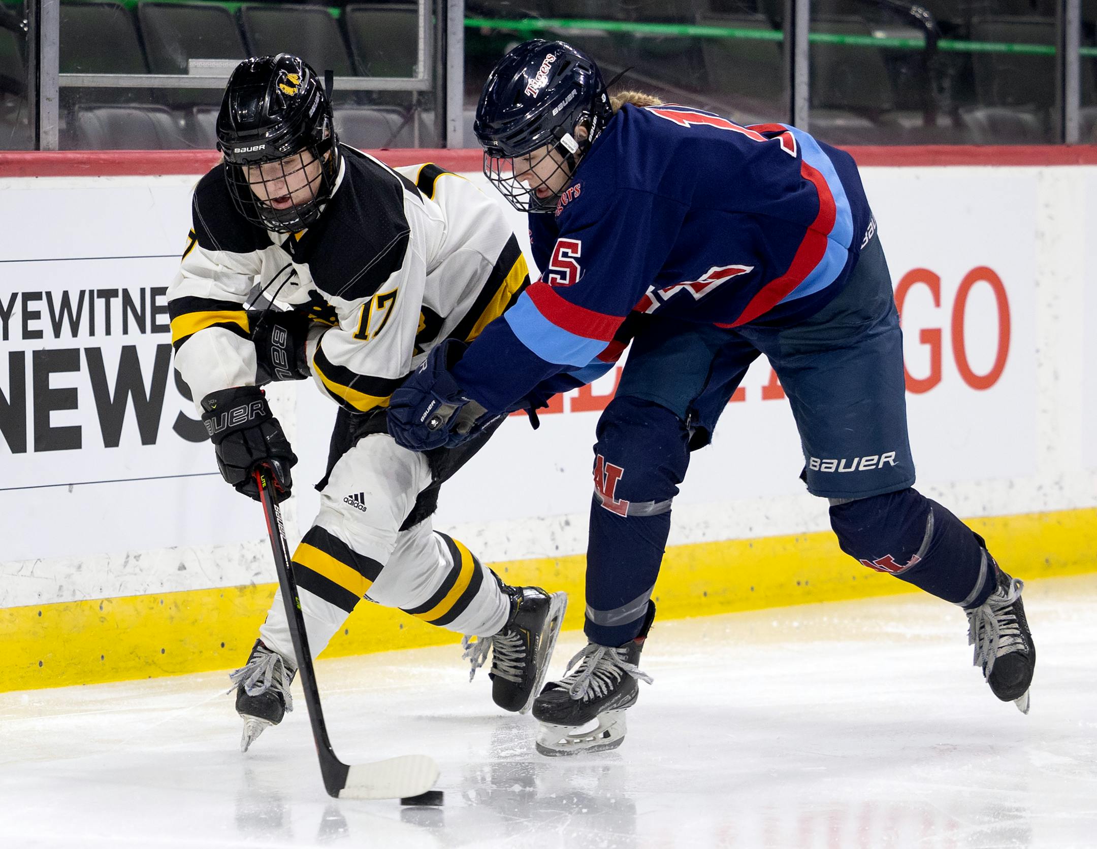 Abbey Reule (17) of Warroad and Emery Nelson (5) of Albert Lea fight for the puck in the first period.