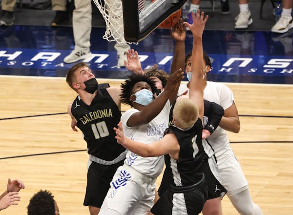 Caledonia's Jackson Koepke (10) and Austin Klug (3) defend Minneapolis North's Mario Sanders (1) under the basket in the Class 2A semifinal Wednesday 