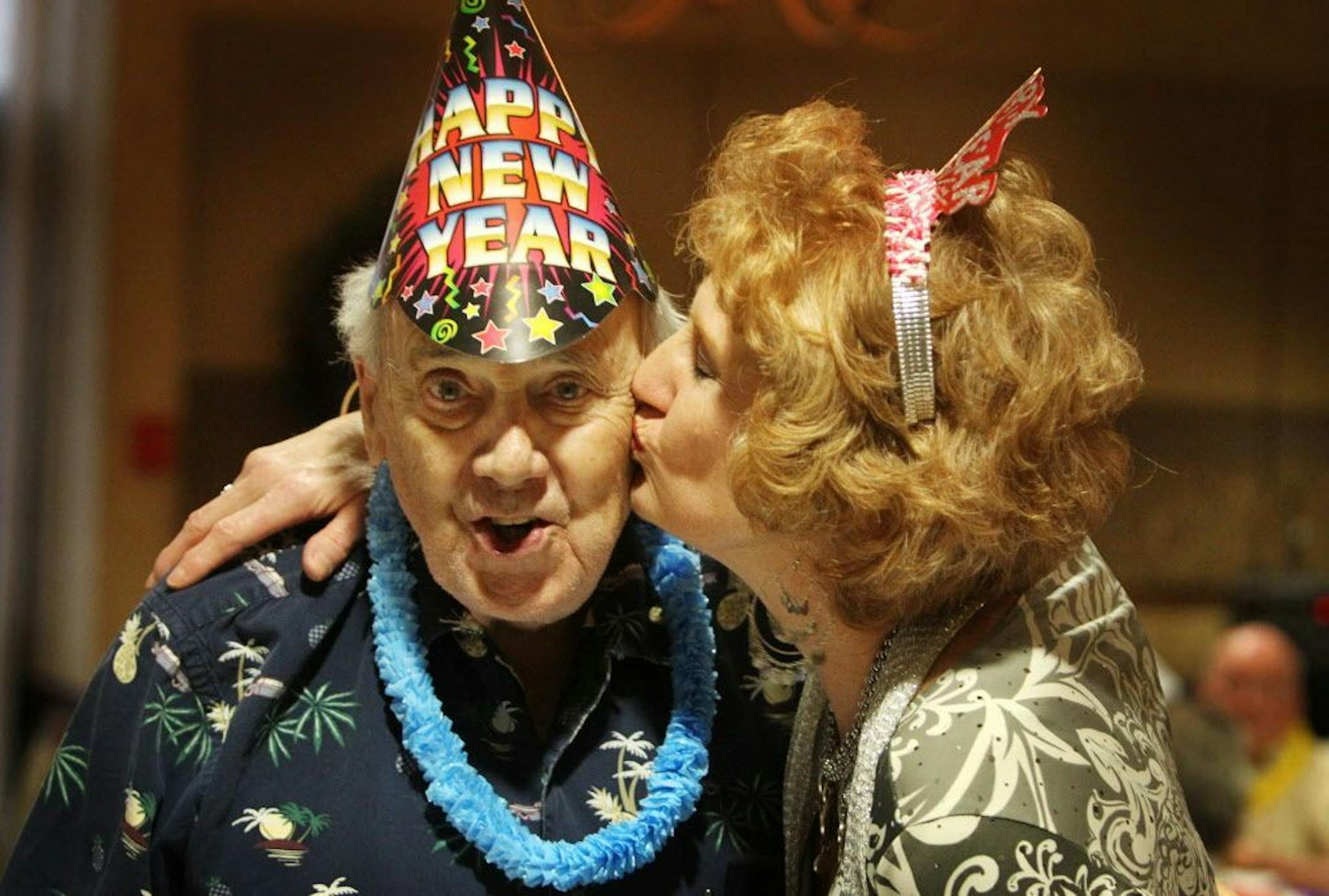 Residents of Walker Place - an independent living facility for residents 60 to 100 years old enjoyed a pre-New Year's Eve happy hour celebration where they were treated to live music, finger food, party hats and favors and champagne flowing in anticipation of the arrival of 2011. In this photo:] Resident James Drummond gets a surprise New Year's kiss from Glenda Reid, Walker Place activities coordinator and resident services director, during the gathering.