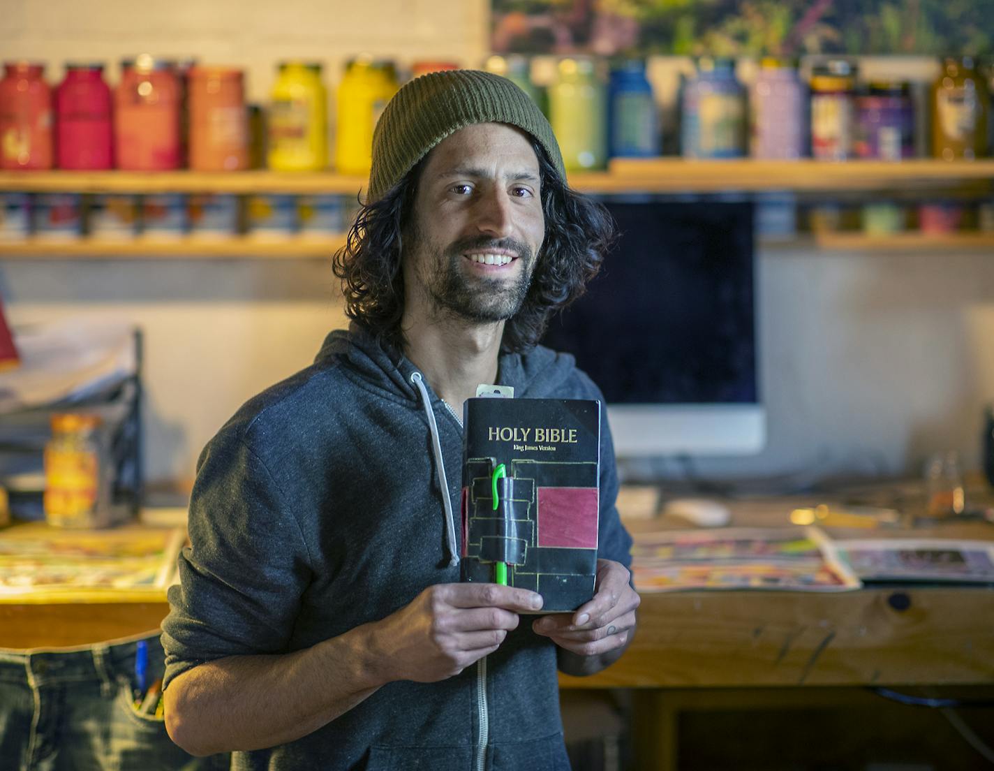 Six years ago, artist Sam Robertson started illustrating the Old Testament. He's not a religious guy, but the good book turned out to be inspiring fodder. Robertson's version is no St. John's Bible. His weird, neon depictions include scenes of Tupperware parties, toilet plungers and plastic ball pits. Here, Robertson is photographed in his basement studio, Friday, May 10, 2019 in Minneapolis, MN. ] ELIZABETH FLORES &#x2022; liz.flores@startribune.com