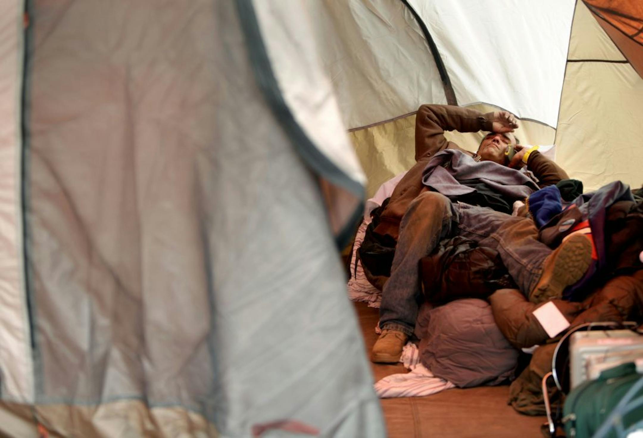 FILE - In this file photo of Nov. 20, 2012 photo, Anthony Gatti makes a call while resting in a tent where he is living in the Midland Beach section of the Staten Island borough of New York. The image of his brother trapped in a car with water rising to his neck, his eyes silently pleading for help, is part of a recurring nightmare that wakes Anthony Gatti up, screaming, at night. Gatti hauled his brother out of the car just in time, saving his life at the height of Superstorm Sandy. The two men