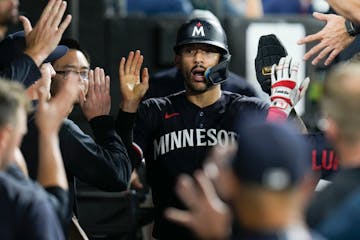 Minnesota Twins' Carlos Correa celebrates in the dugout after scoring when Matt Wallner reached on a fielding error by Chicago White Sox first baseman