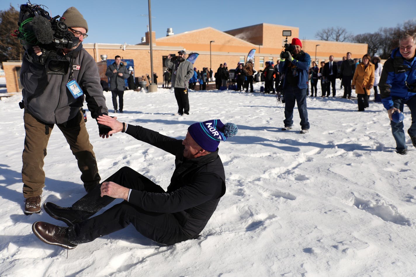 NFL Commissioner Roger Goodell was helped up by a Fox 9 photojournalist after he fell trying to catch a pass while playing with a group of students following a "snow shoveling ceremony" in place of ground breaking ceremony for the school's new athletic field.