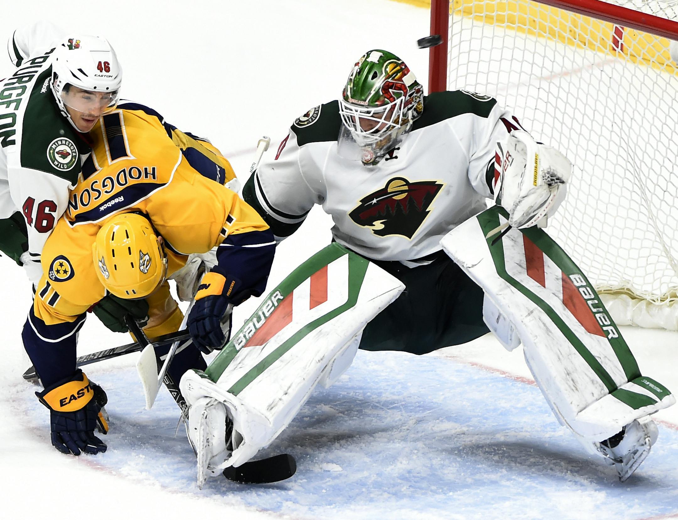 Minnesota Wild defenseman Jared Spurgeon (46) collides with Nashville Predators center Cody Hodgson (11) as Wild goalie Devan Dubnyk (40) deflects a shot above in the third period of an NHL hockey game Saturday, Dec. 19, 2015, in Nashville, Tenn. The Predators won 3-2. (AP Photo/Mark Zaleski)