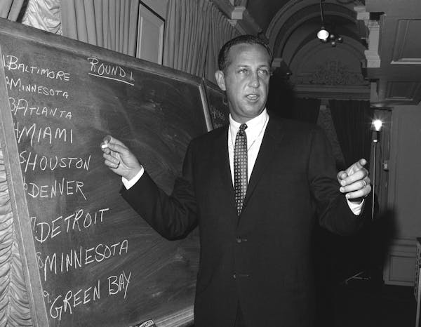 Pete Rozelle, professional football commissioner, works at blackboard at hotel in New York City on March 14, 1967 as he conducts the combined National