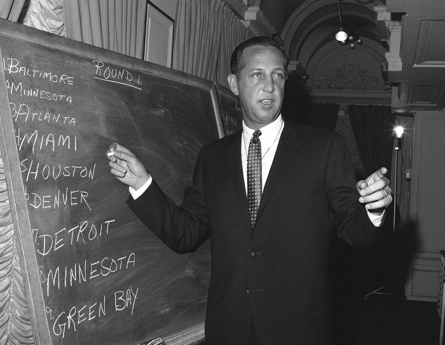 Pete Rozelle, professional football commissioner, works at blackboard at hotel in New York City on March 14, 1967 as he conducts the combined National Football League (NFL) - American Football league (AFL) player draft.