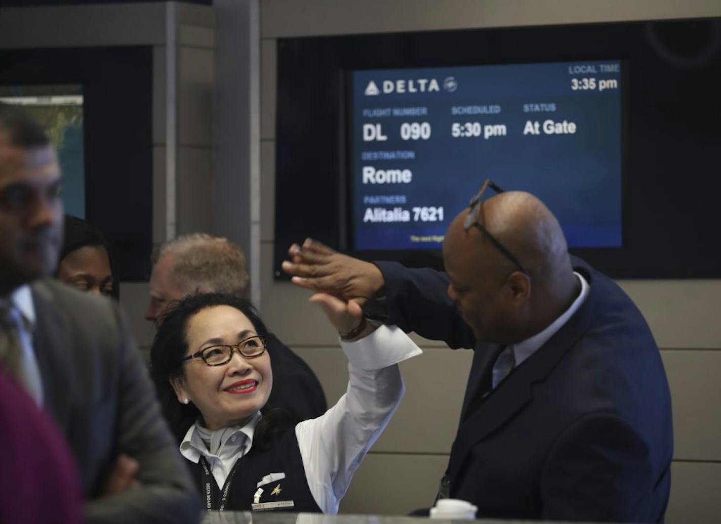 Gate agents Song Schuler and Mauricio Clarke high fived each other as the celebration of the fist flight to Rome was underway and passengers were checking in Wednesday afternoon.