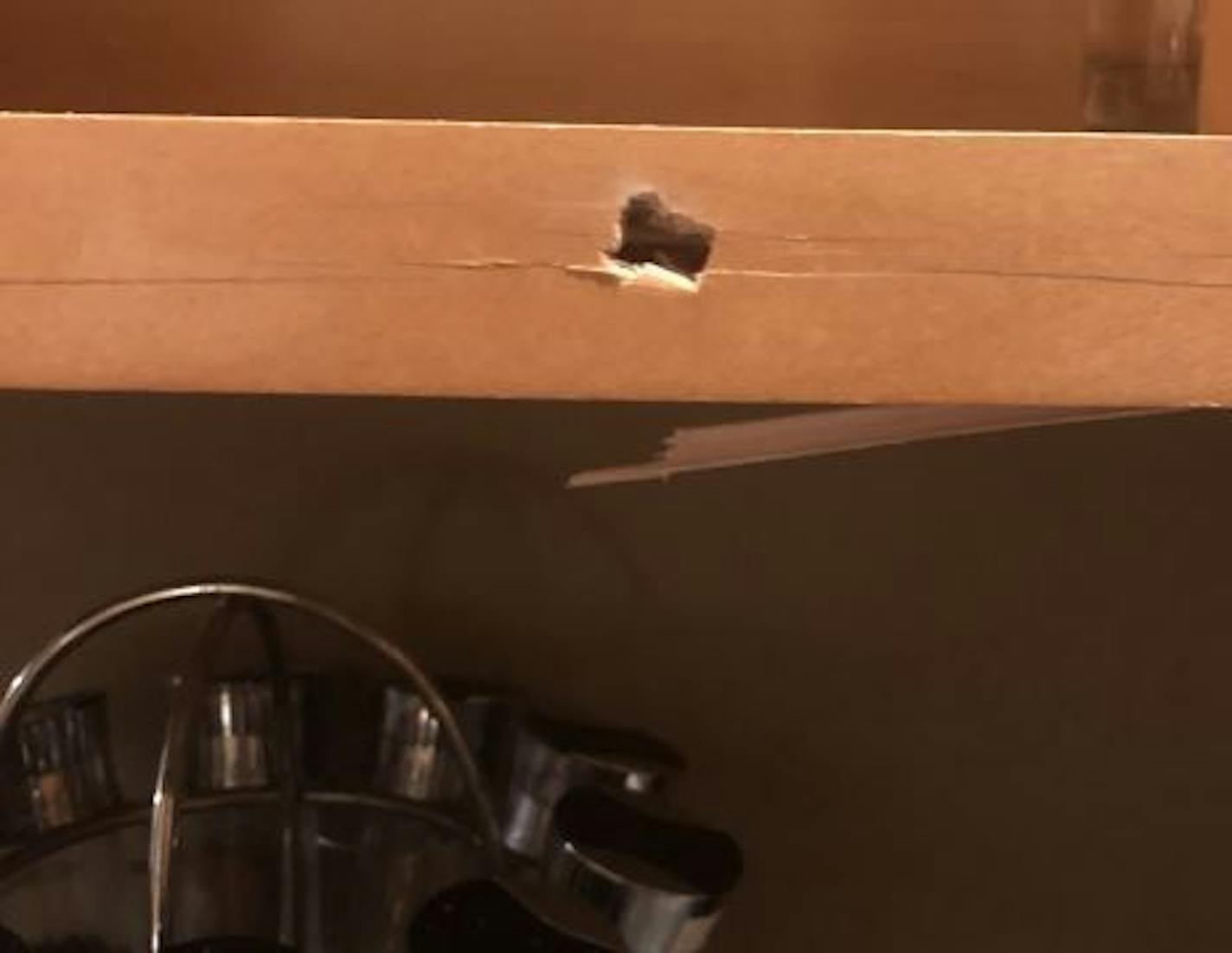 The bullet ended up lodged in the bottom of a cupboard. Credit: Submitted photo