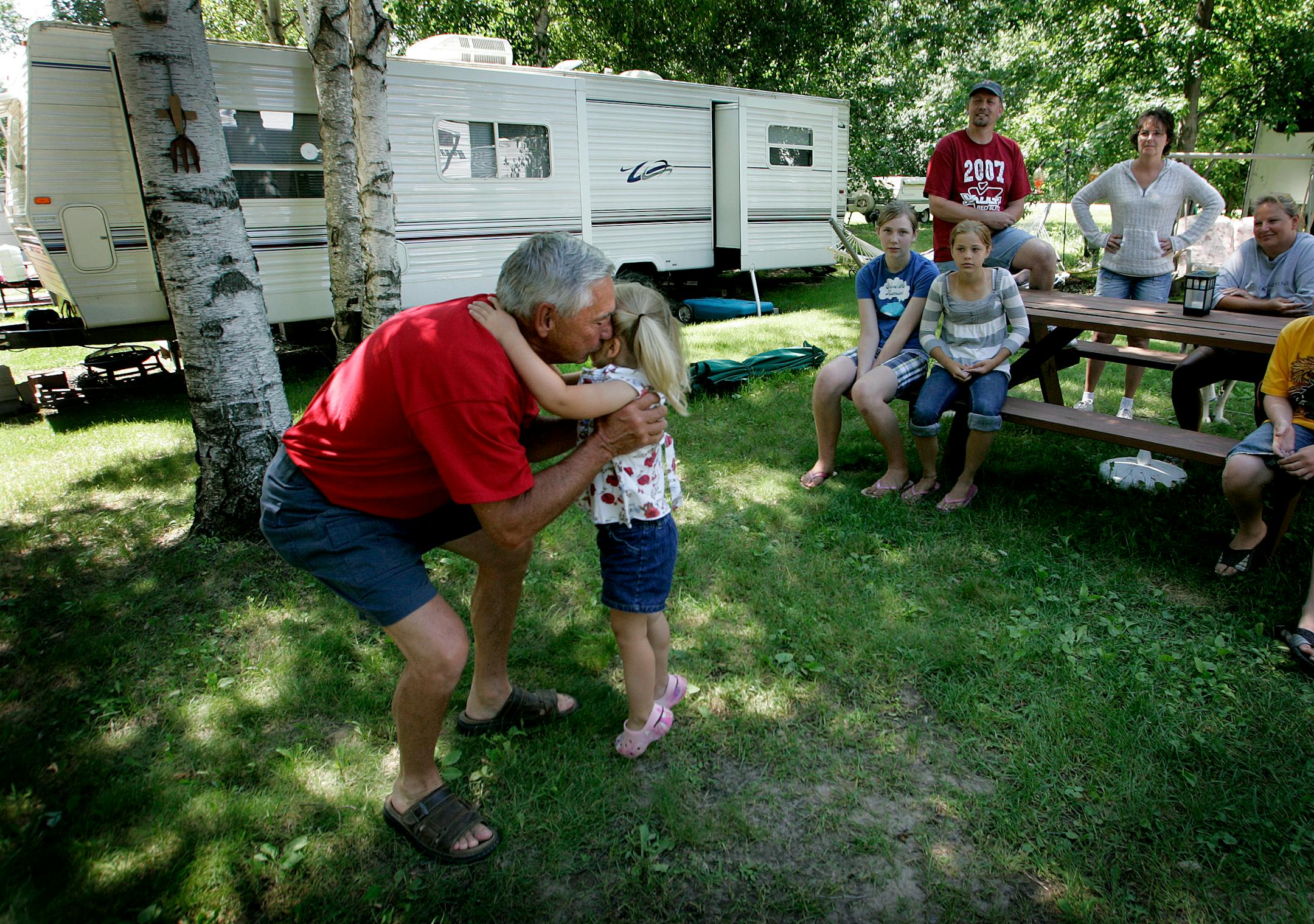 Chuck Cronquist, a Vietnam veteran and organizer of the camp, hugged his granddaughter Jennifer Sievers, 3, near his family's camper. "We know how to take care of people with a lot of problems because we came from the same place," he said. "We're all related because we were all in the service."