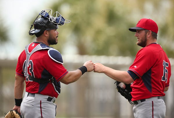 Twins catcher Josmil Pinto and pitcher Glen Perkins bumped fists after Pinto caught for Perkins during batting practice at Hammond Stadium.