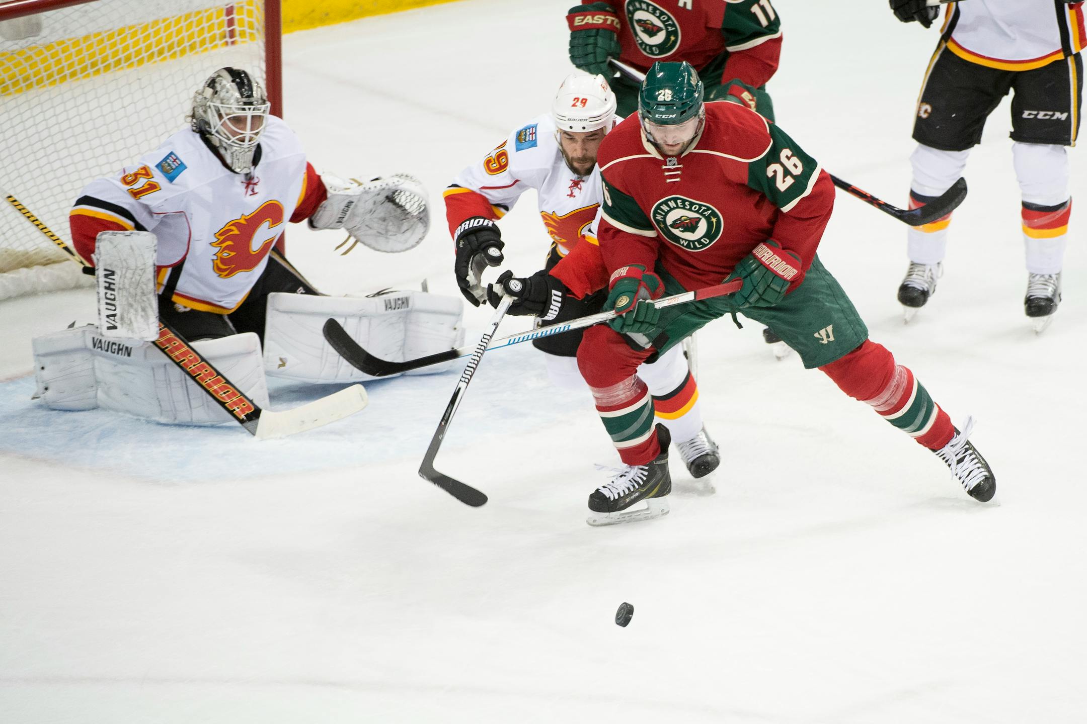Minnesota Wild right wing Thomas Vanek (26) tries to put himself in scoring position while being defended by Calgary Flames defenseman Deryk Engelland (29) with Karri Ramo (31) in the goal during the first period.