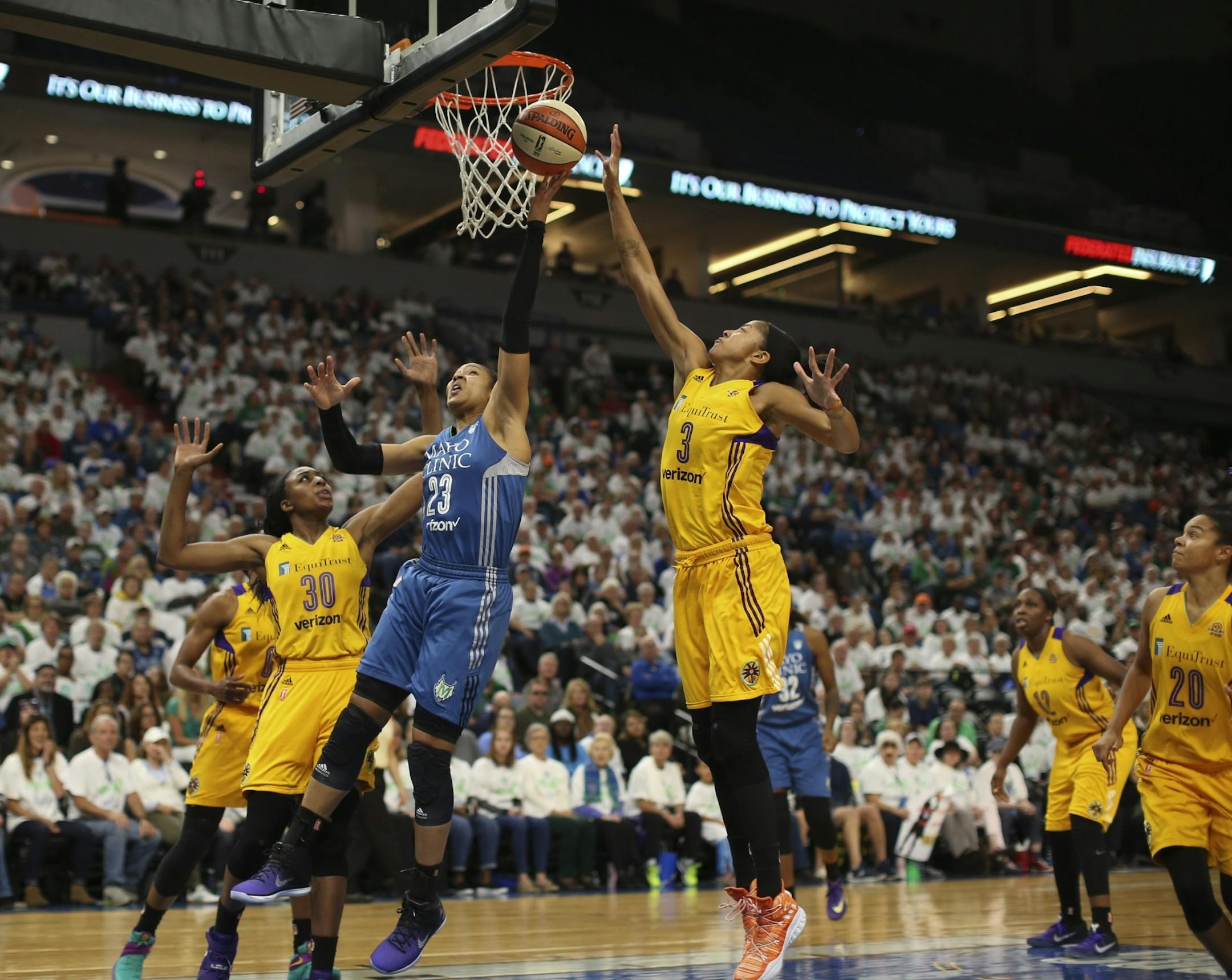 Minnesota Lynx forward Maya Moore (23) shot between the defense of Los Angeles Sparks forward Nneka Ogwumike (30) and Candace Parker (3). She finished with 18 points.