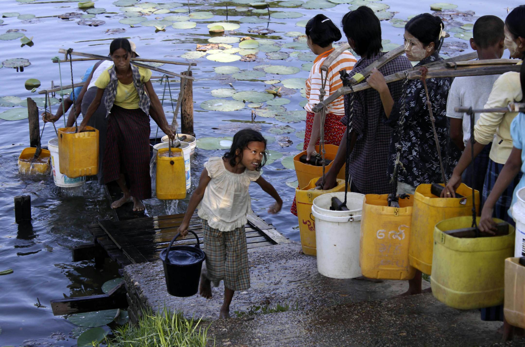 Local residents fetch drinking water with the use of plastic containers on Tuesday, March 22, 2011, in Dala, about 15 km south of Yangon, Myanmar. To solve the growing global water crisis, the United Nations created March 22 as World Water Day, an international day of observance, in 1992. (AP Photo/Khin Maung Win) ORG XMIT: MYN101