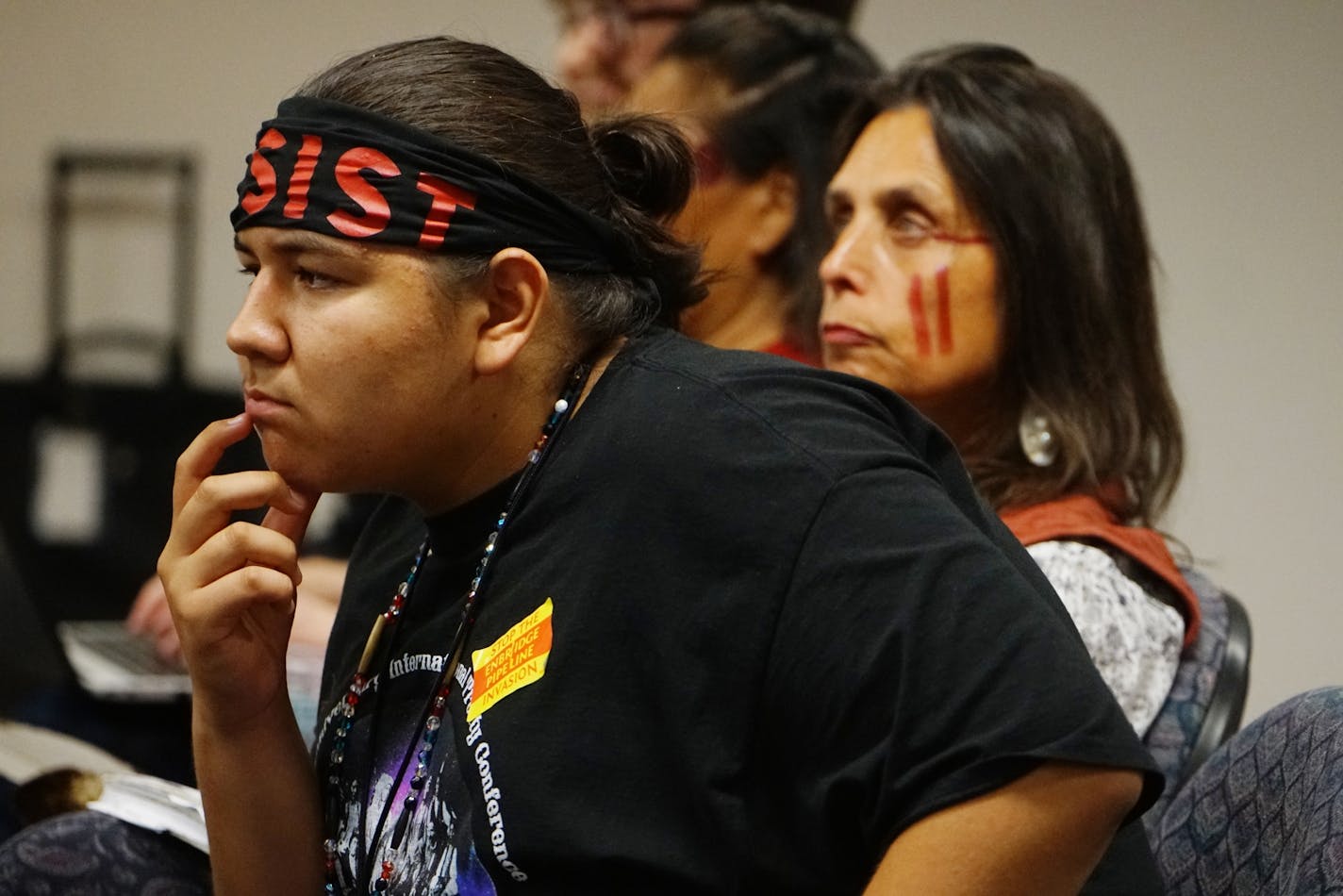 Nolan Berglund, a Native American high school student sat in attendance with a headband that reads "resist."