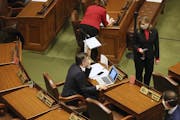 Minnesota House Speaker Melissa Hortman, standing, right, confers with Majority Leader Ryan Winkler, left, as the House met to take up several bills, 