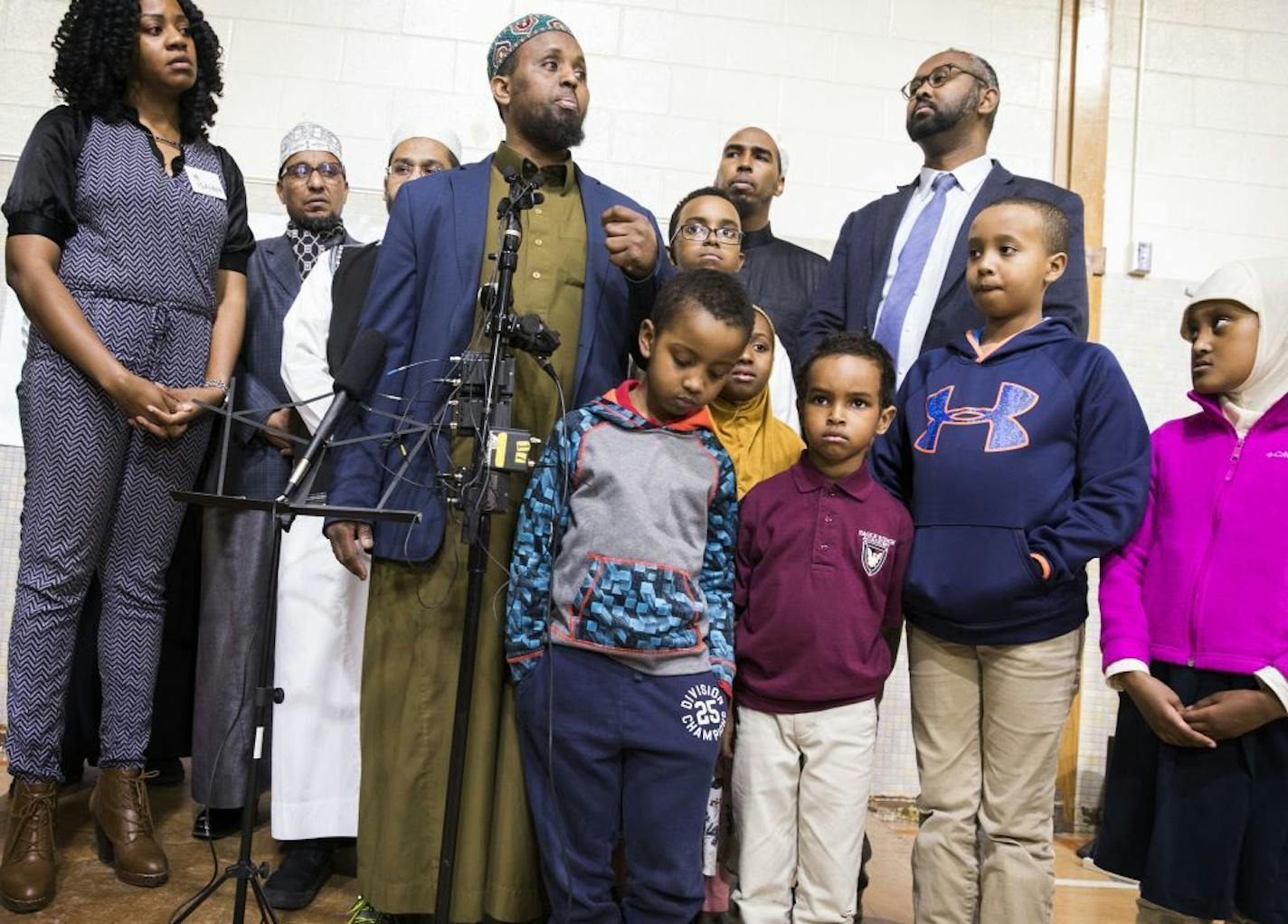 Dar Al Farooq Islamic Center Executive Director Mohamed Omar, center, spoke about the charges filed against three people in the bombing of the mosque in 2017. He was surrounded by community members and children from Dar Al Farooq.