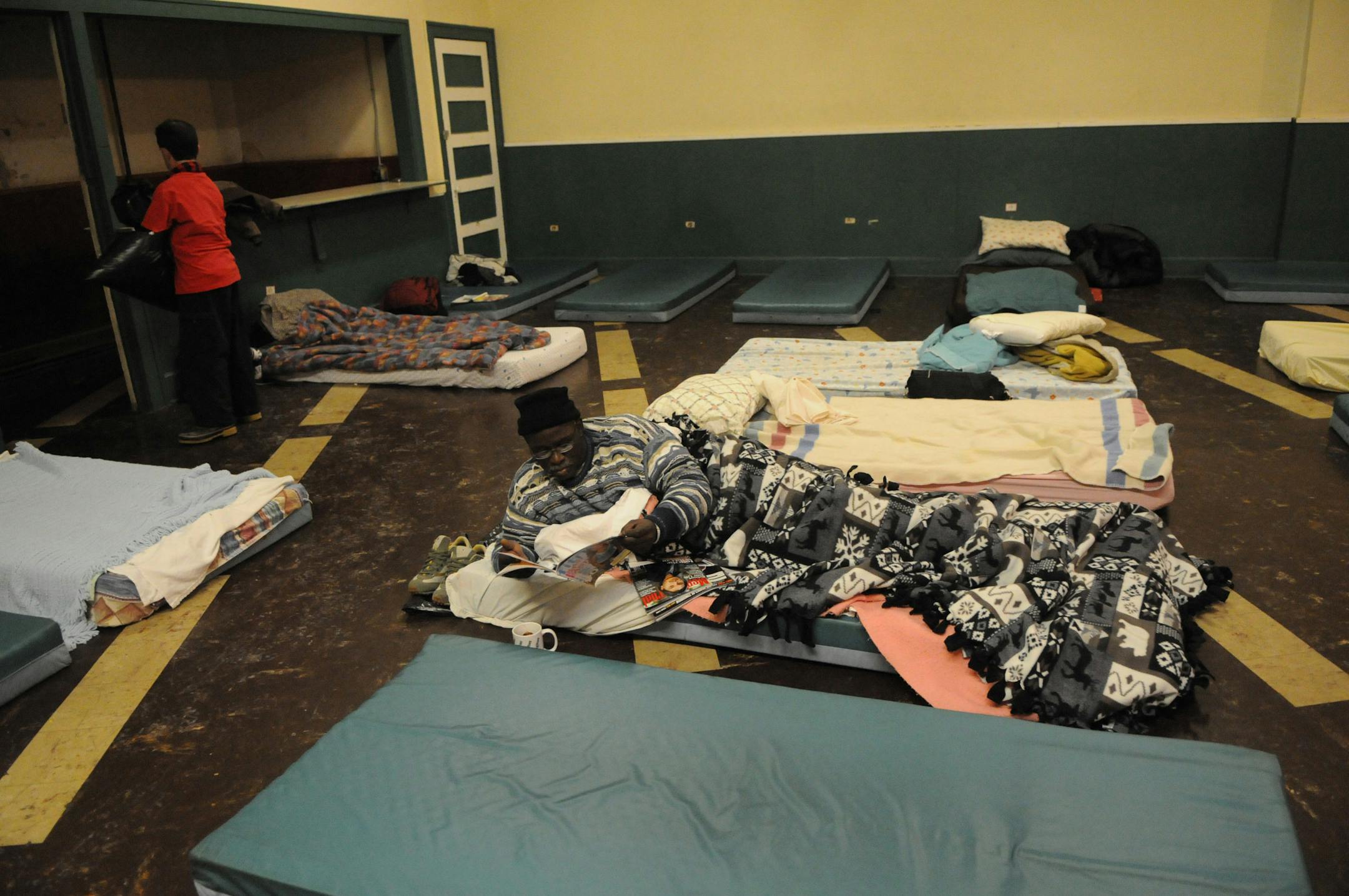 On cold winter nights, shelter clients fervently hope their number is drawn, even for accommodations like these. This client reads in his bed on the main floor.