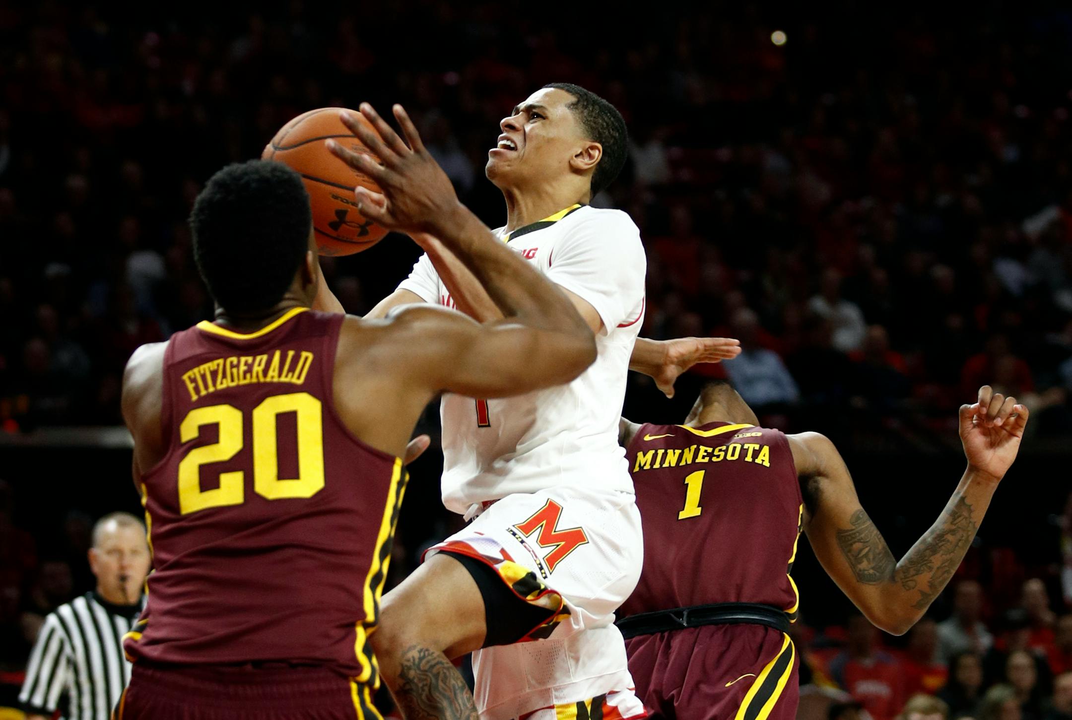 Maryland guard Anthony Cowan, center, shoots between Minnesota forward Davonte Fitzgerald (20) and guard Dupree McBrayer during the second half of an NCAA college basketball game in College Park, Md., Thursday, Jan. 18, 2018. Maryland won 77-66. (AP Photo/Patrick Semansky)
