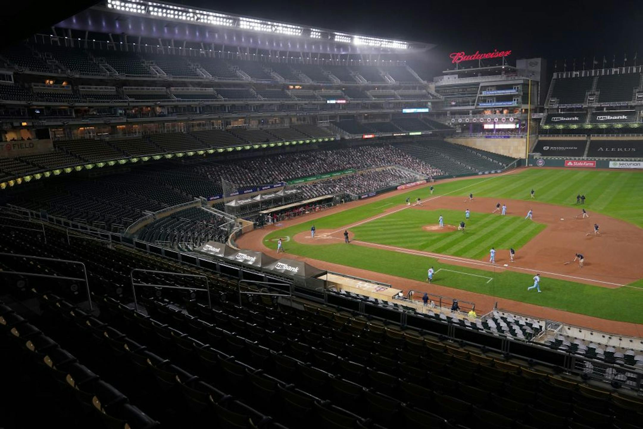 The Minnesota Twins grounds crew worked to spread dry dirt on the infield as a light ran fell on Target Field at the start of the seventh inning.