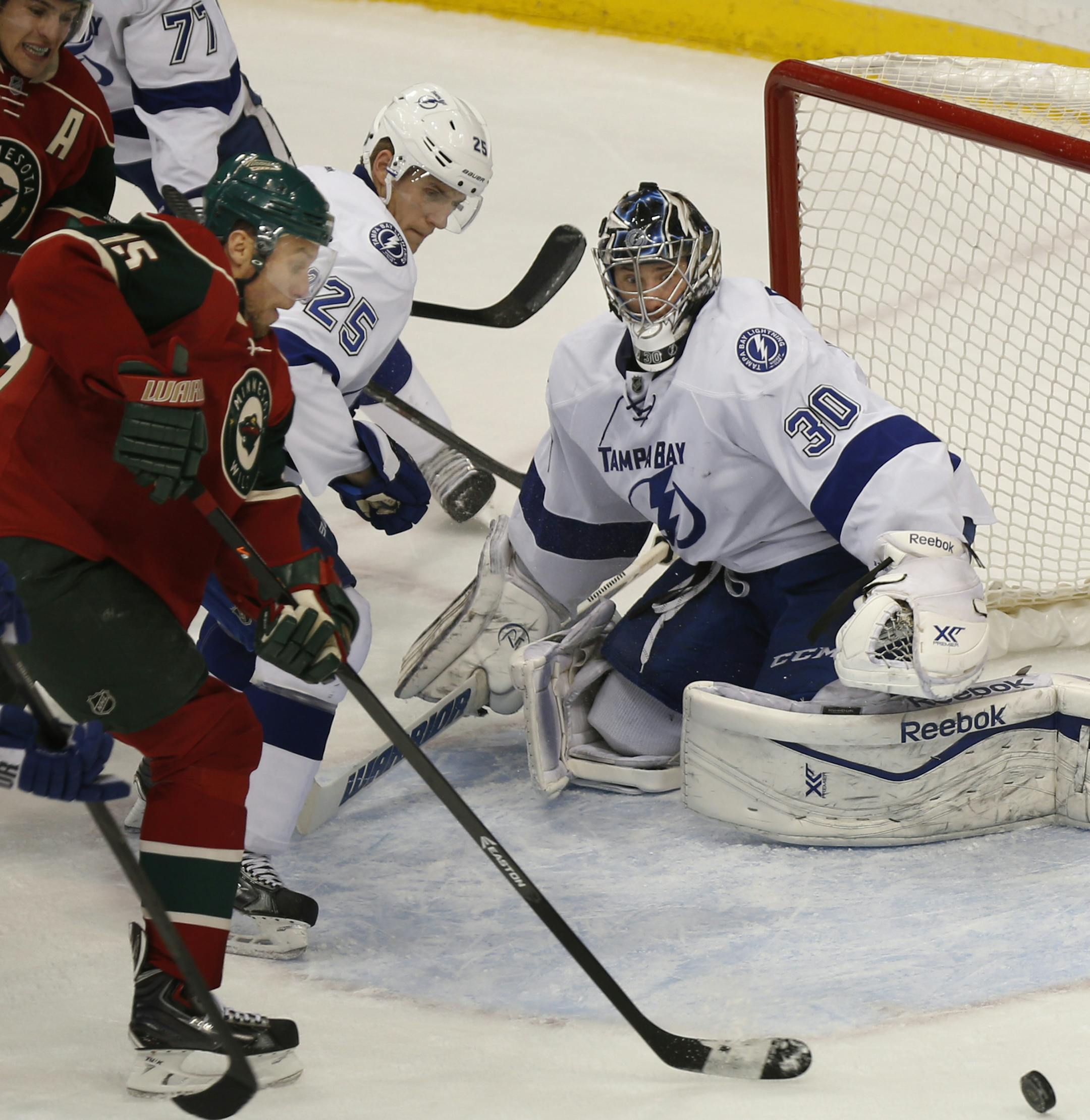 At the Xcel Energy Center in a game between Tampa Bay and the Wild, Ben Bishop(30) defends an attack from Dany Heatley(15) .]rtsong-taatarii@startribune.com