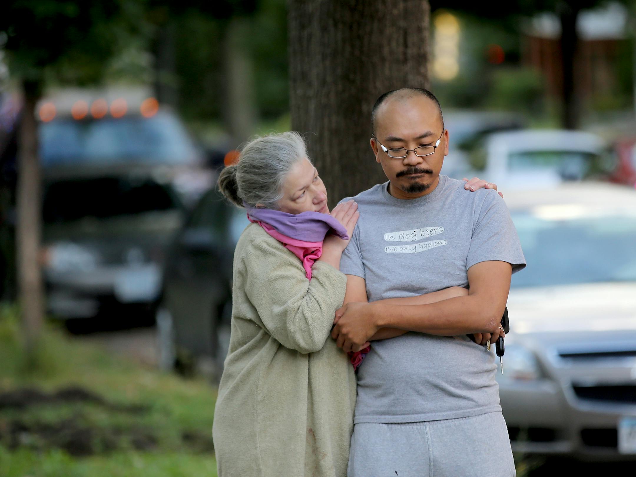A man who did not wish to give his name but identified himself as a downstairs tenant, right, is comforted by an unidentified person after the the duplex he was living in was gutted by fire Thursday, Sept. 28, 2017, in Minneapolis, MN. The man assisted in helping the upstairs tenant to safety and also was able to get his two dogs to safety before the fire spread.
