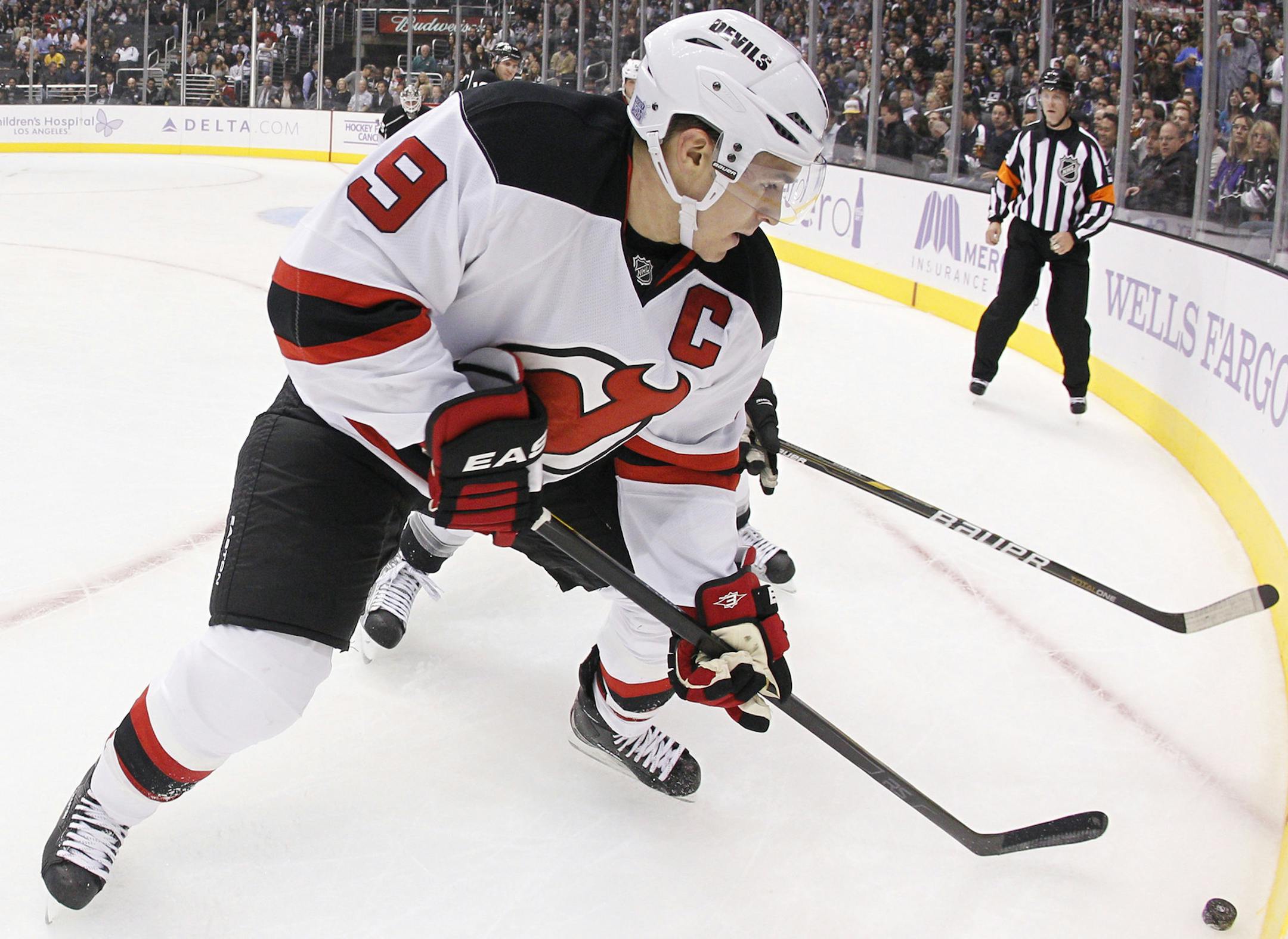 New Jersey Devils left wing Zach Parise goes for the puck during the third period of a NHL hockey game against the Los Angeles Kings in Los Angeles, Tuesday, Oct. 25, 2011. (AP Photo/Ric Tapia)