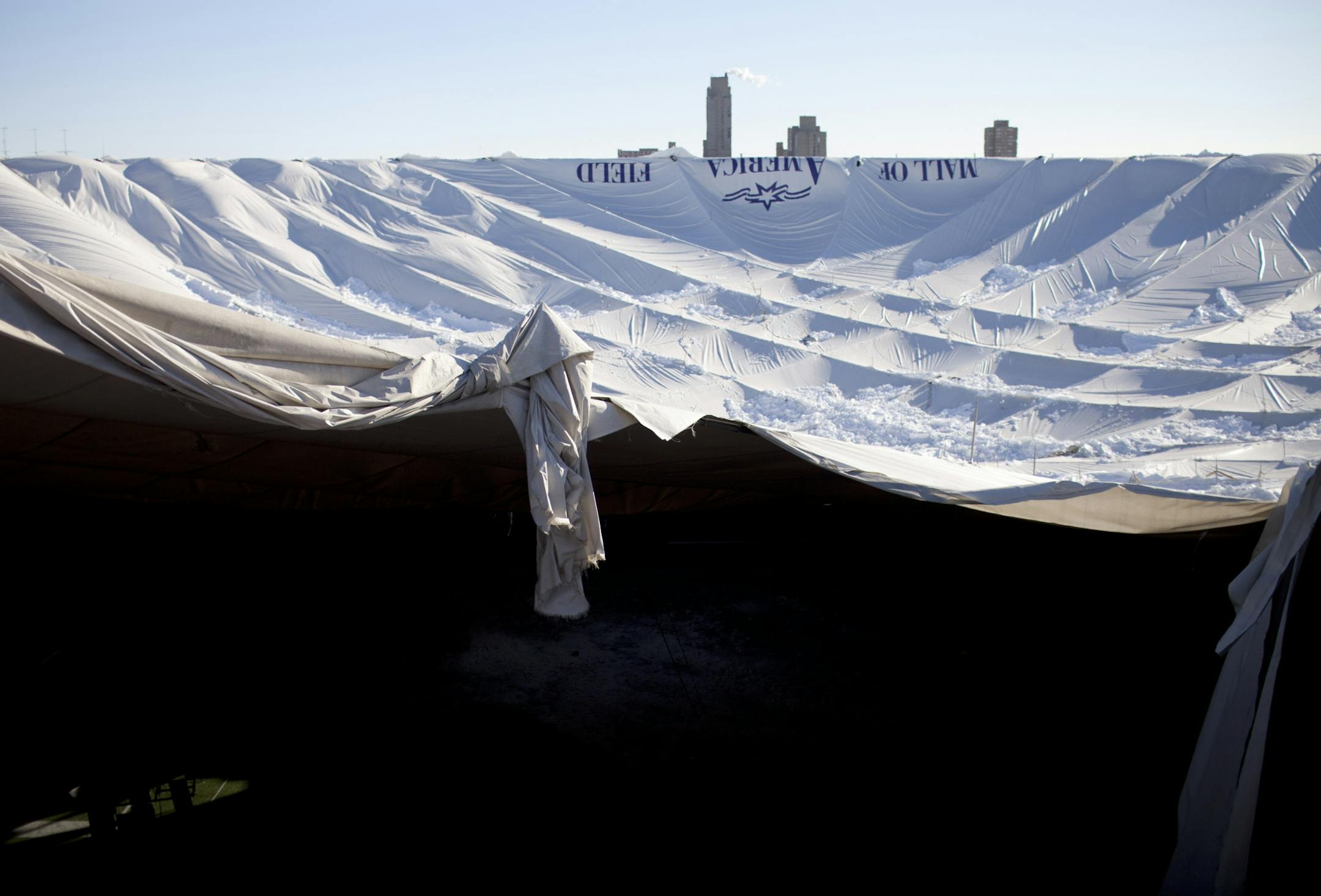 The Cedar Riverside towers can be seen through the torn roof of the Metrodome Sunday morning.