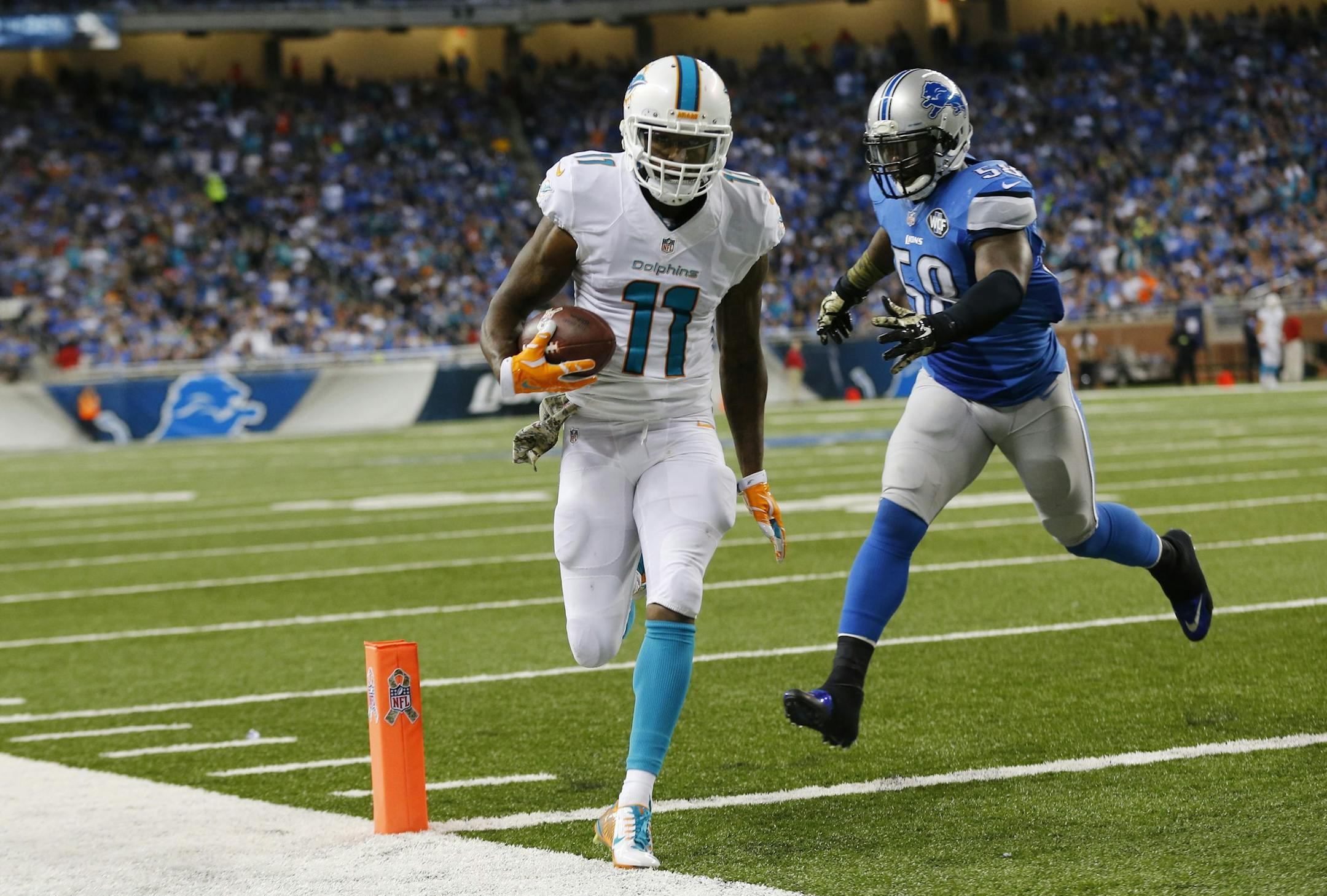 Miami Dolphins wide receiver Mike Wallace (11) outruns Detroit Lions outside linebacker Ashlee Palmer (58) for a three-yard touchdown during the second half of an NFL football game in Detroit, Sunday, Nov. 9, 2014. (AP Photo/Paul Sancya) ORG XMIT: otkco153